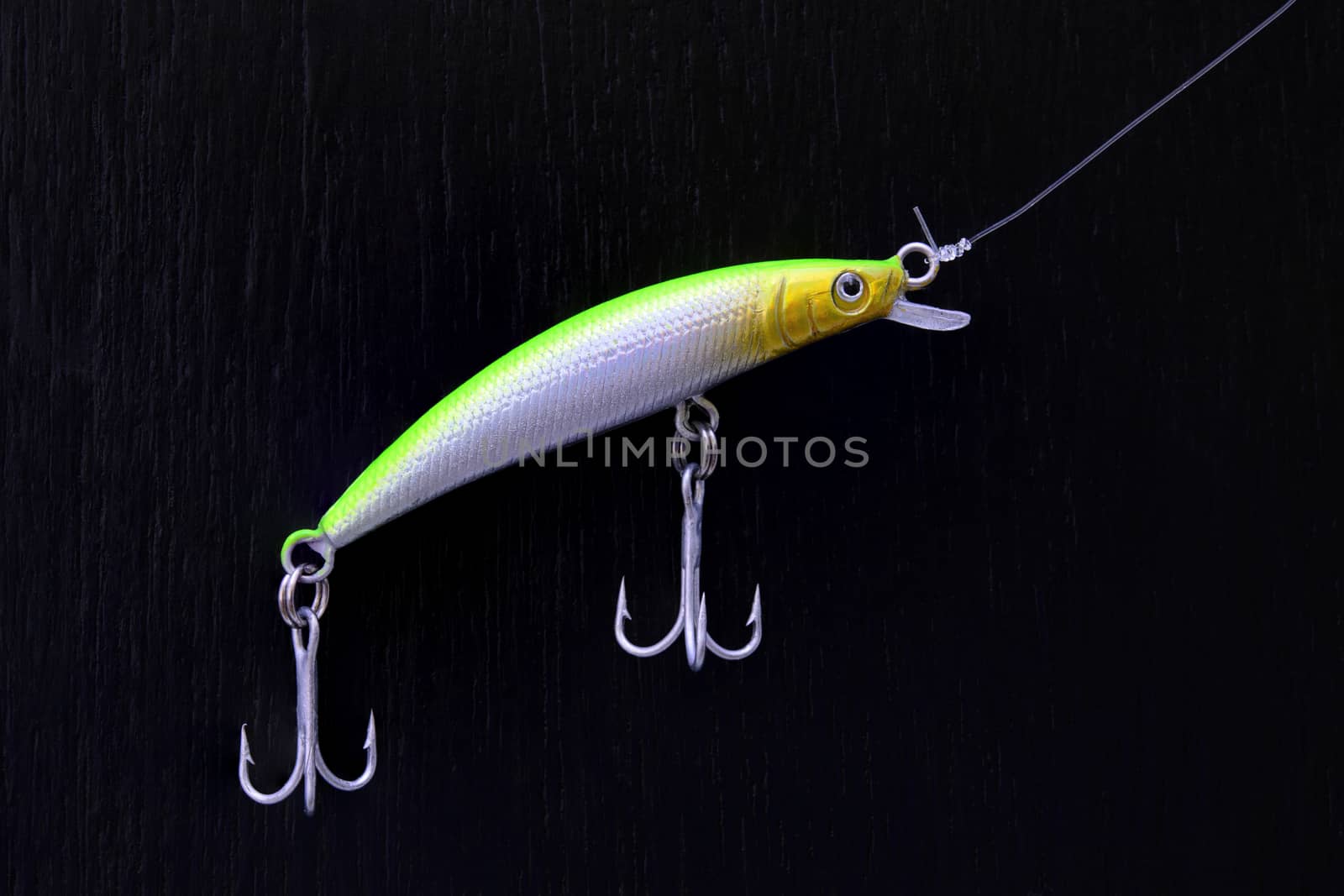 close up of colorful minnow fishing lure on a black board
