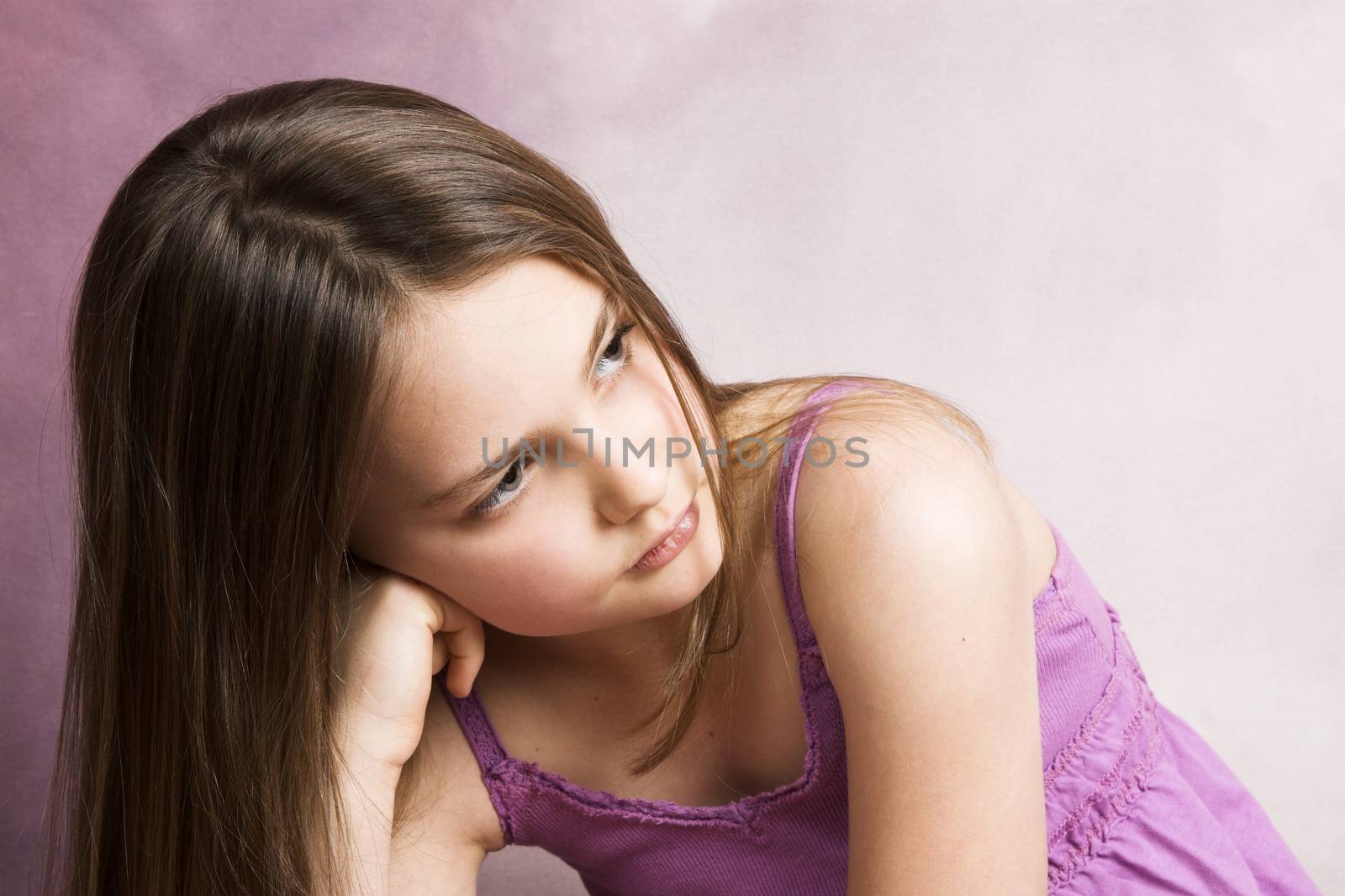 Beautiful young brunette against a pink background
