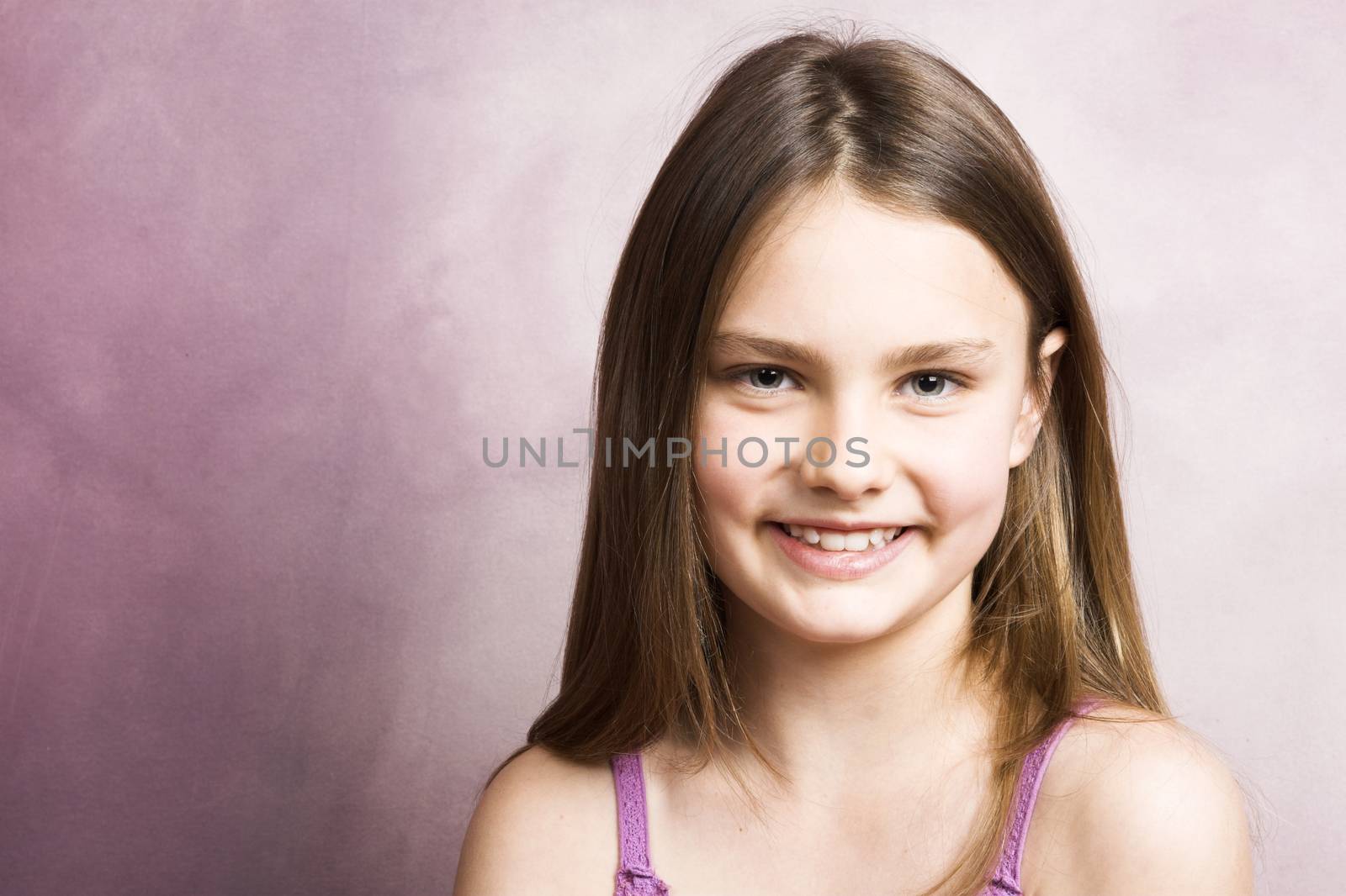 Beautiful young brunette against a pink background
