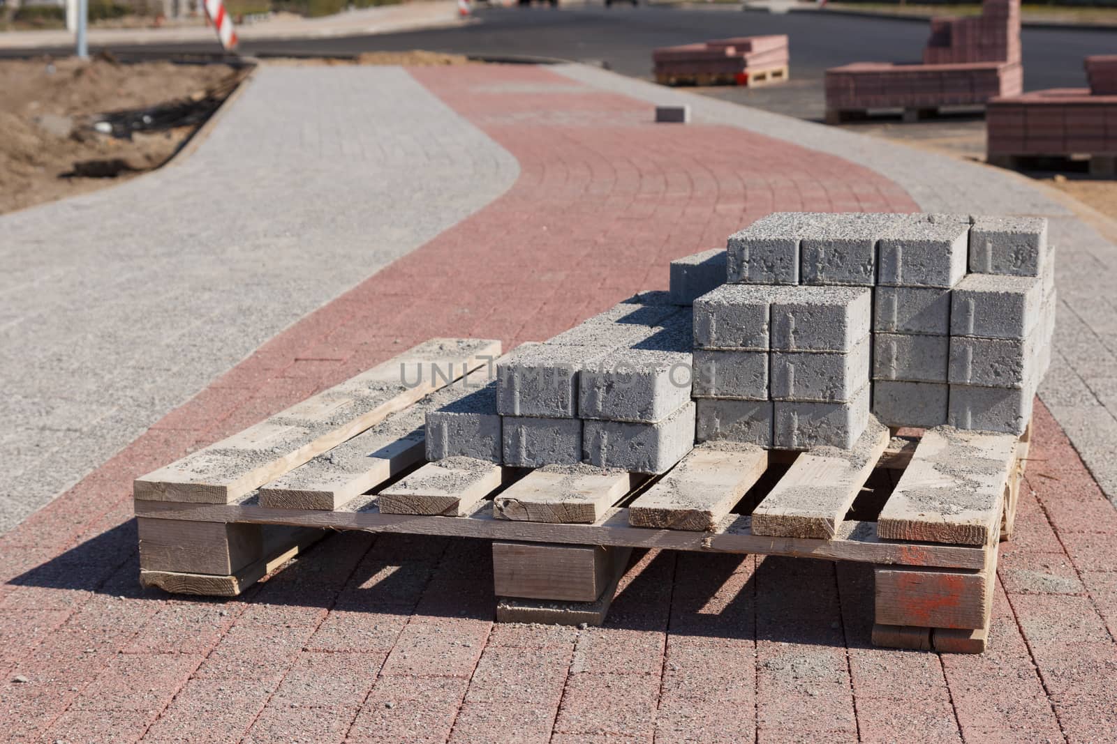 A bunch of road construction bricks placed on a wooden supporter