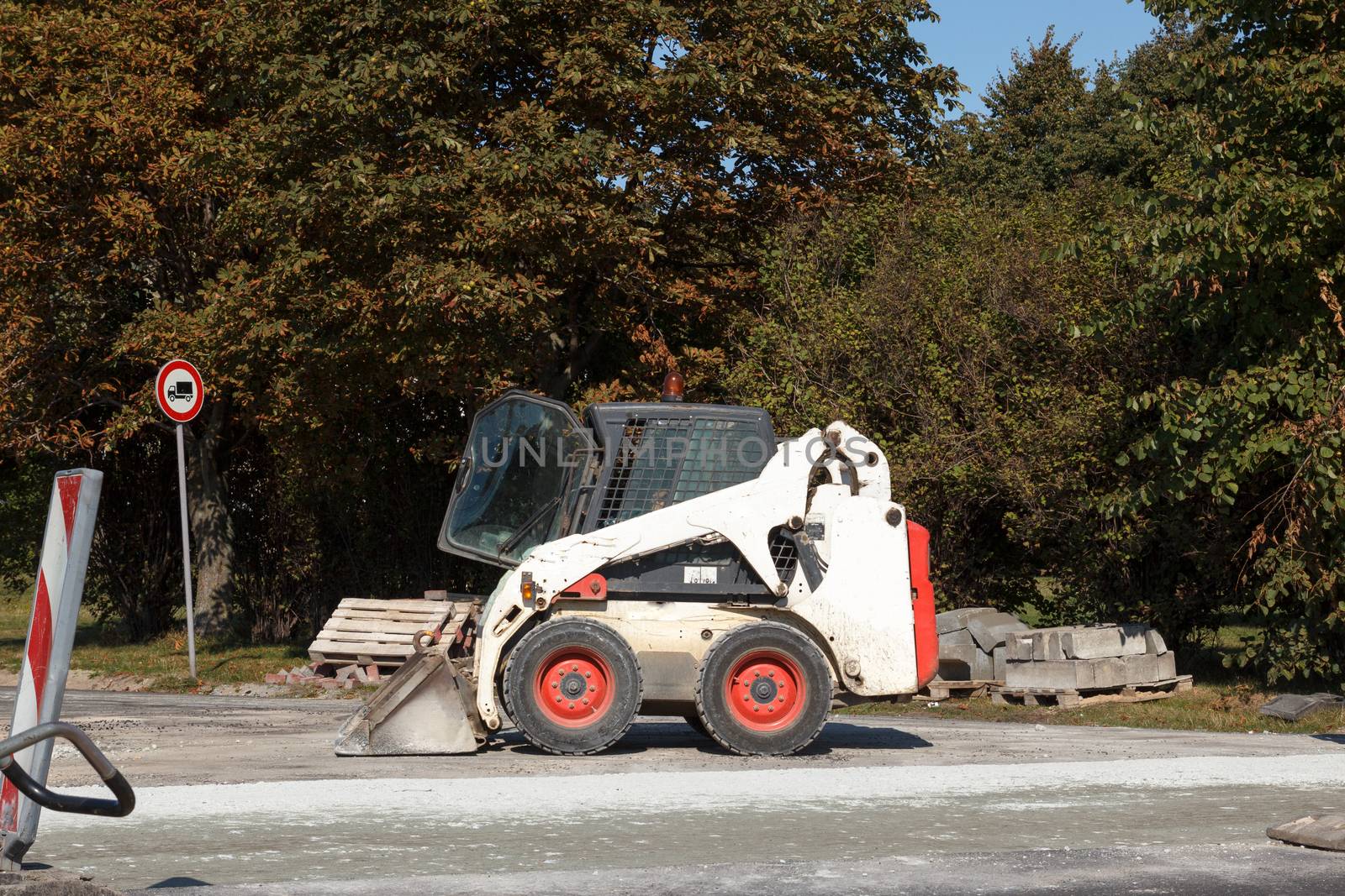 A small excavator Bobcat parked at construction site