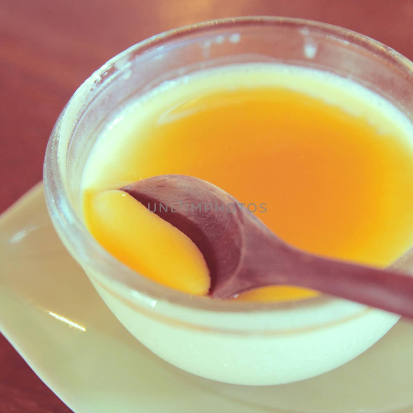 Custard pudding and wooden spoon with retro filter effect by nuchylee