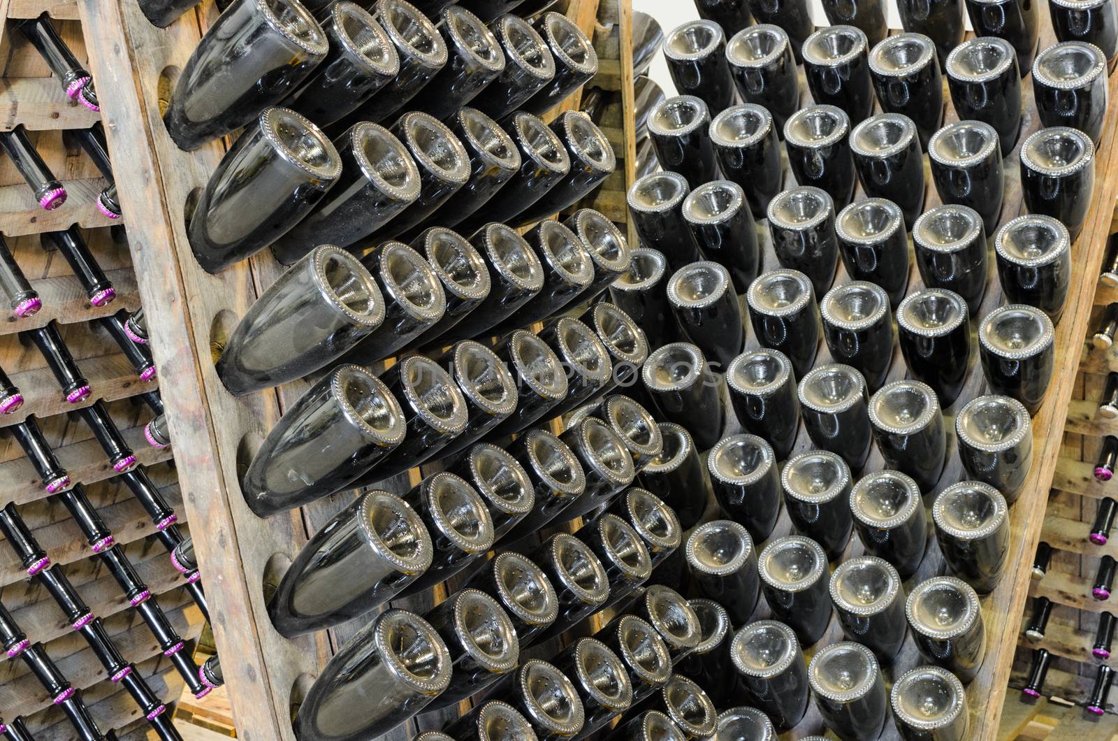 Vintage sparkling wine on rack stand aging in winery production