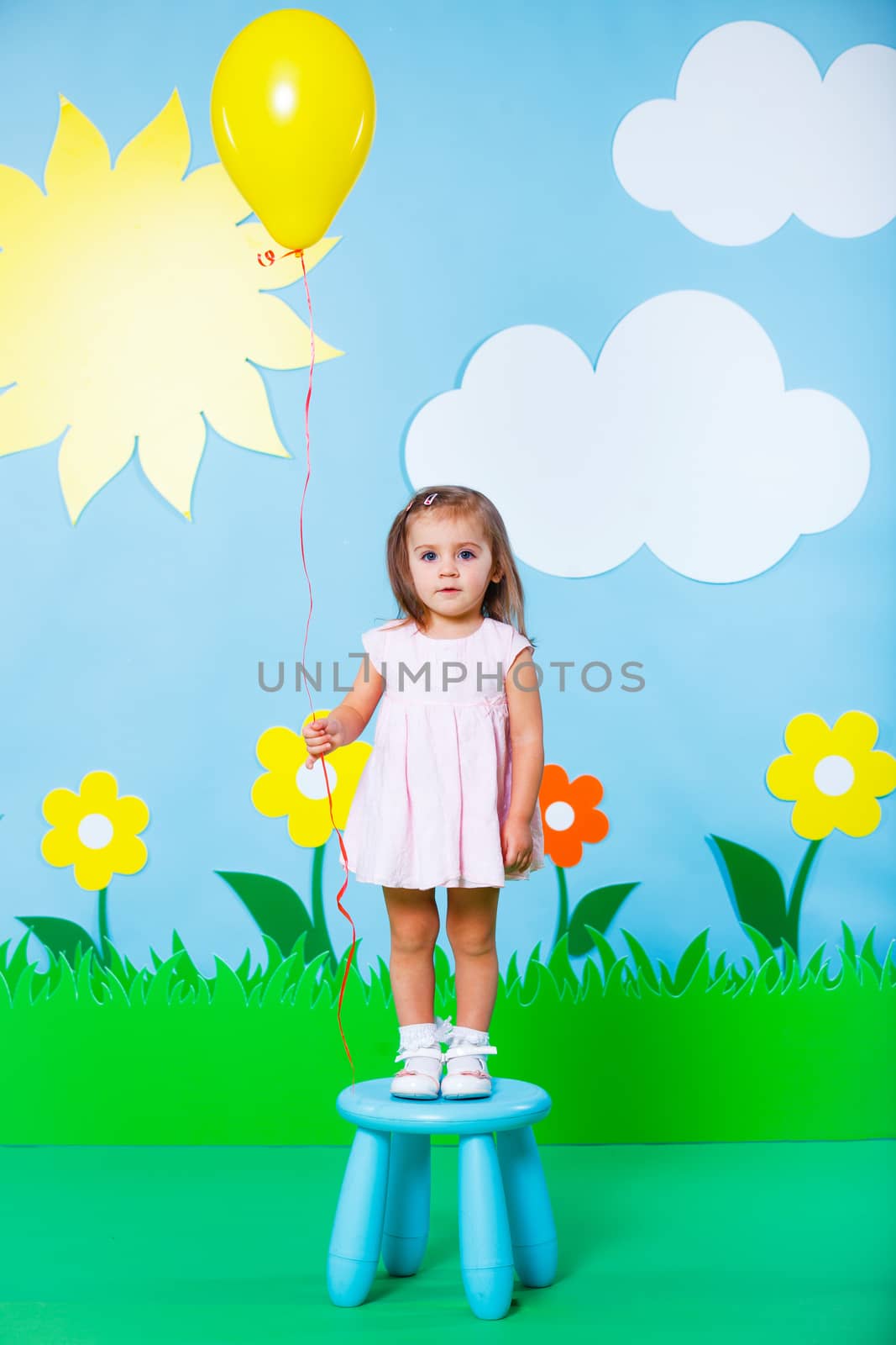 Lovely baby girl wearing colorful summer dress with balloon on Fashion and Beauty Summer theme