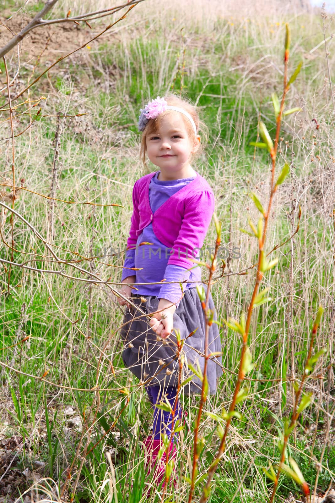 Little girl playing in the field during springtime