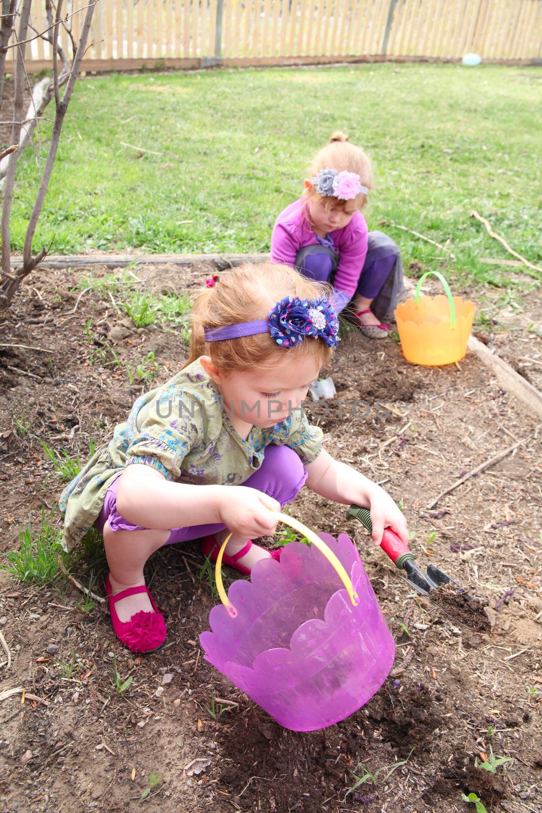 Two sisters planting new flowers in the garden