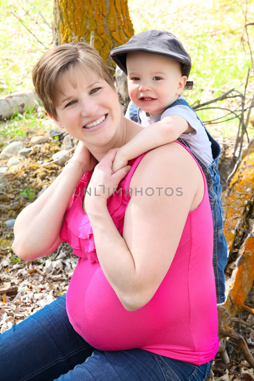 Pregnant mother and son playing in a field