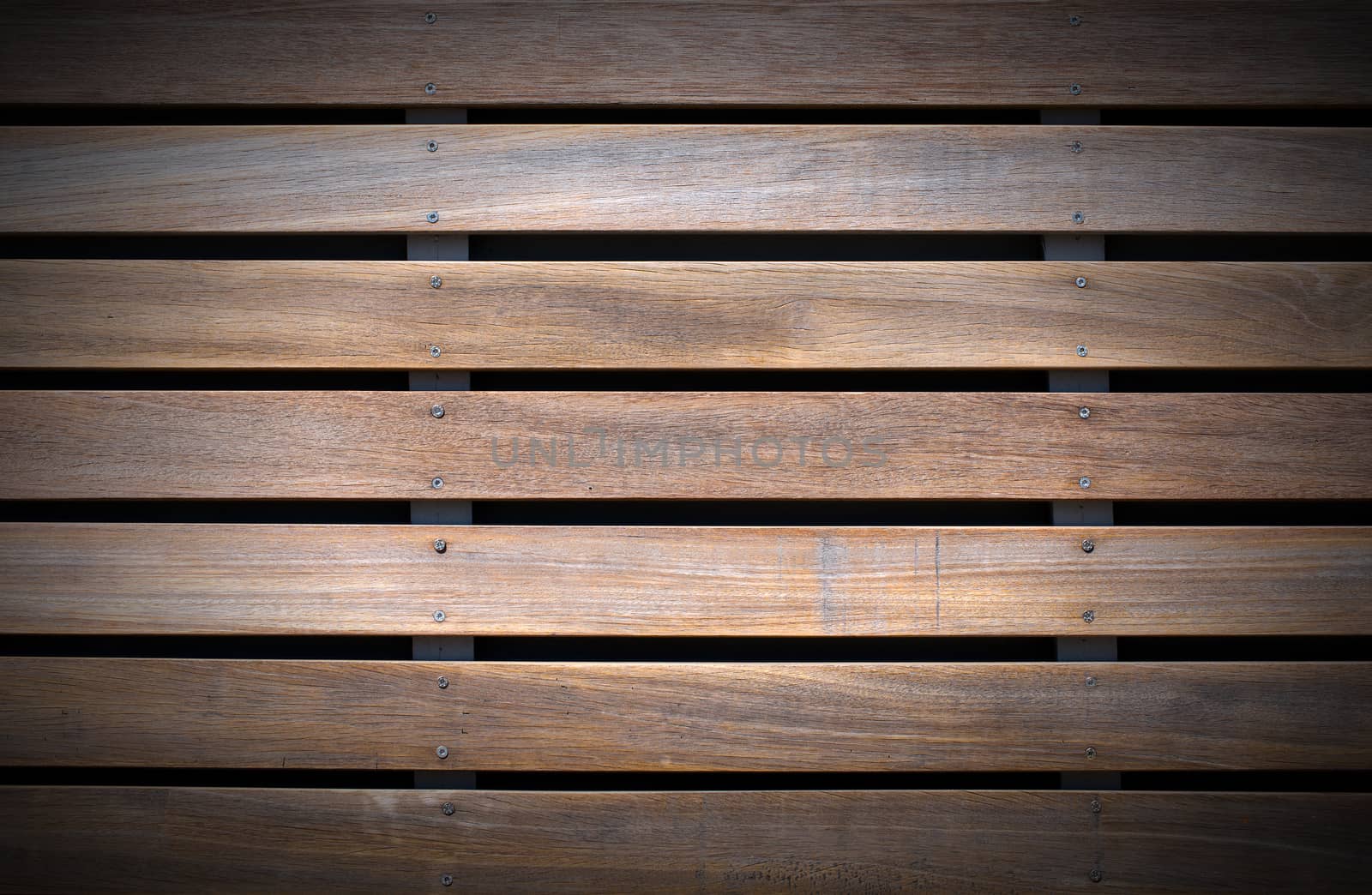 Wooden background with five brown and white boards and screws on black background
