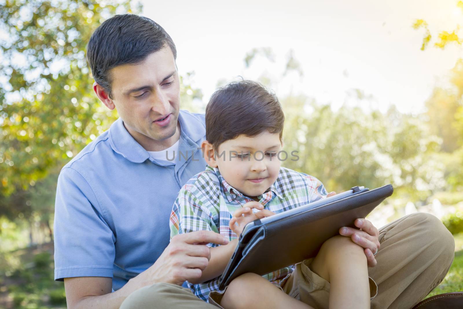 Handsome Mixed Race Father and Son Playing on Computer Tablet by Feverpitched