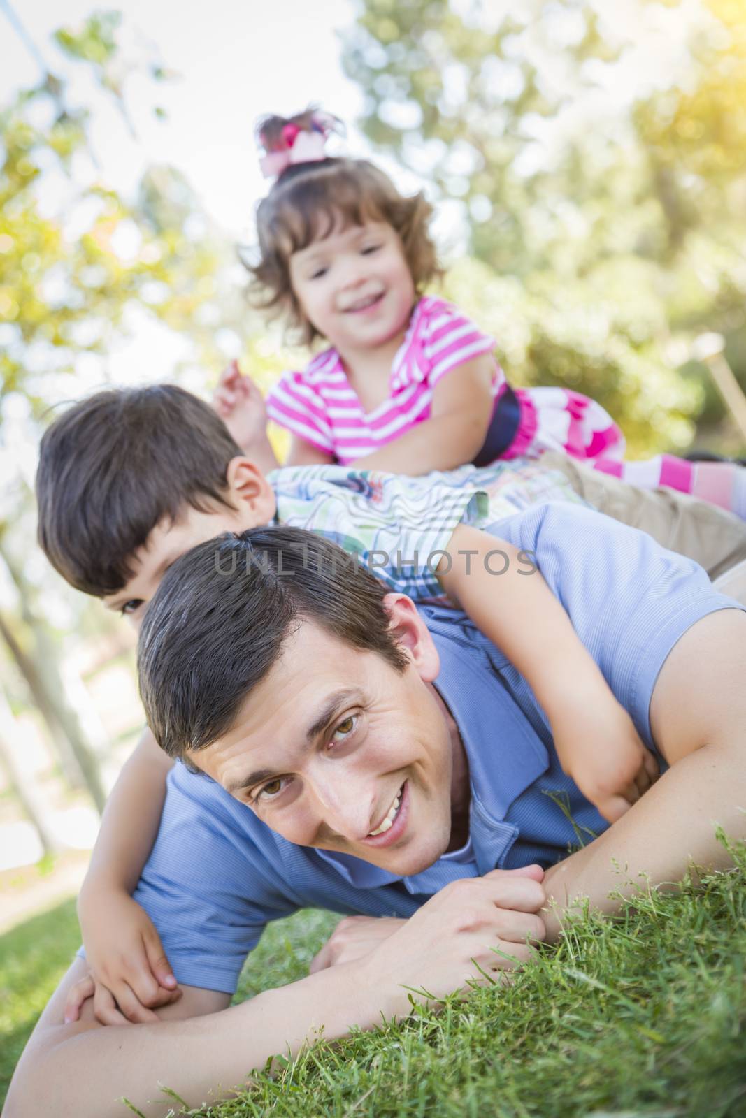 Young Son and Daughter Having Fun With Their Dad Outdoors by Feverpitched
