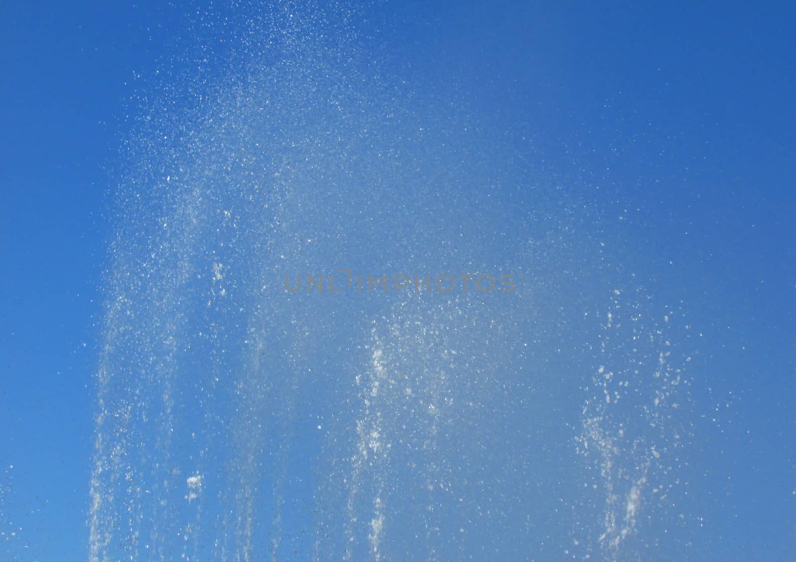 The splashing of the fountain on the background of blue sky