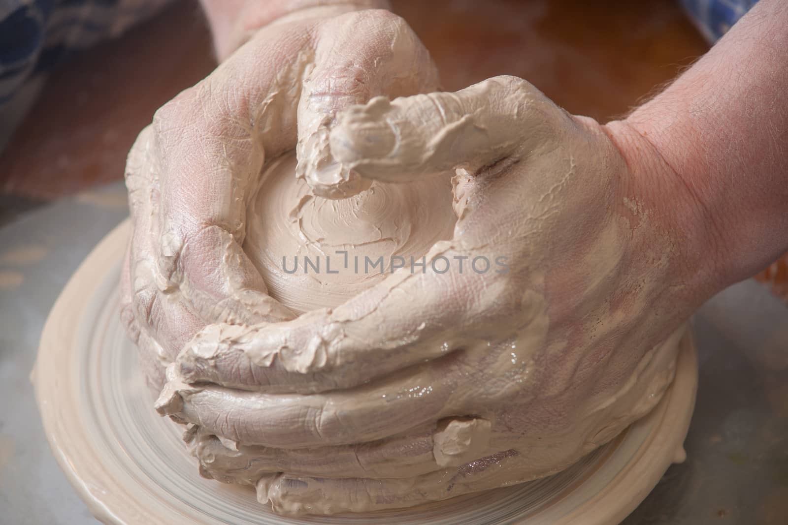 Hands of a potter, creating an earthen jar on the circle