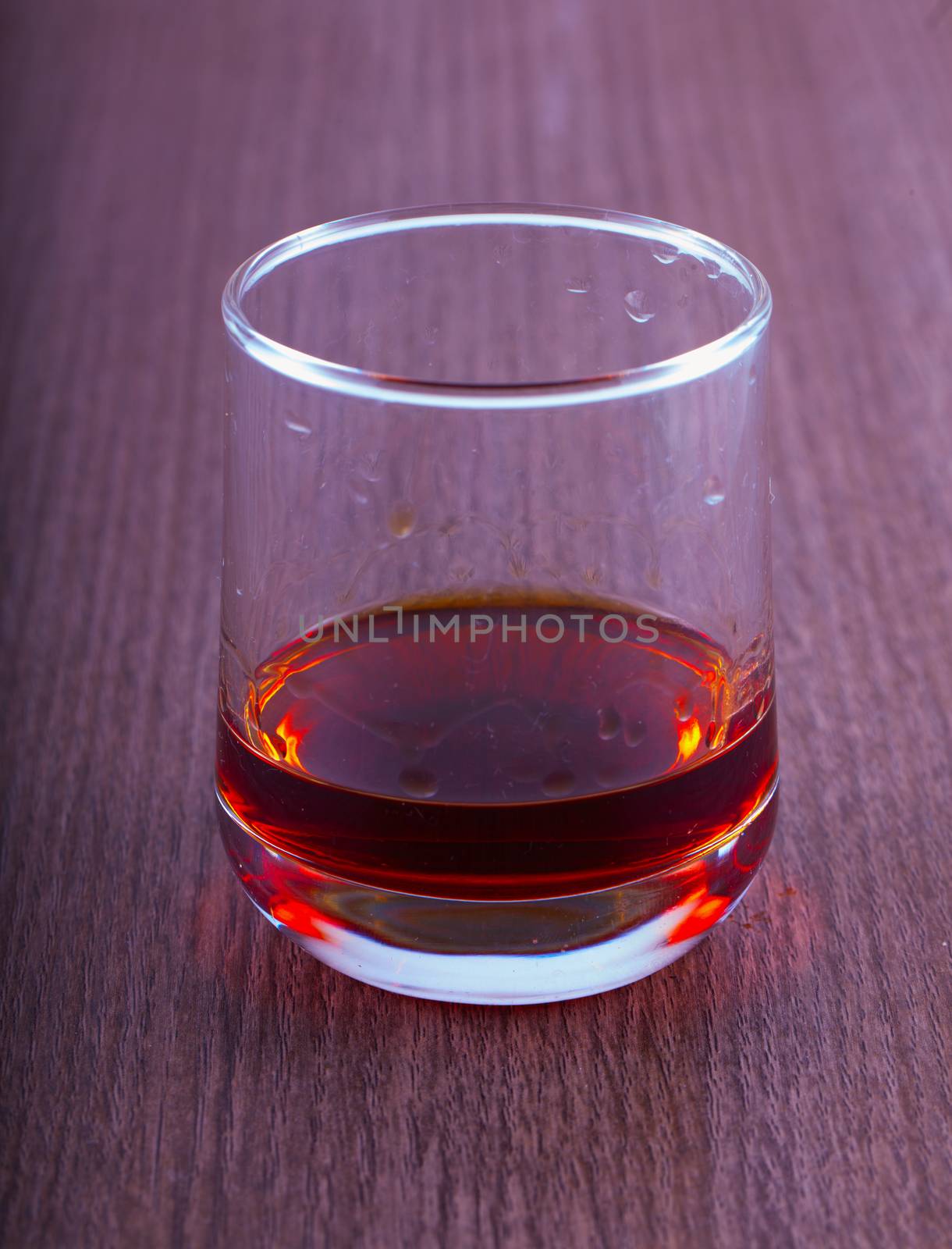 Liquor in a glass over wooden table