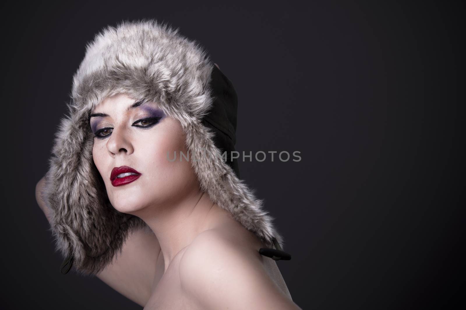 Sexy female green-eyed woman with fur hat, winter concept
