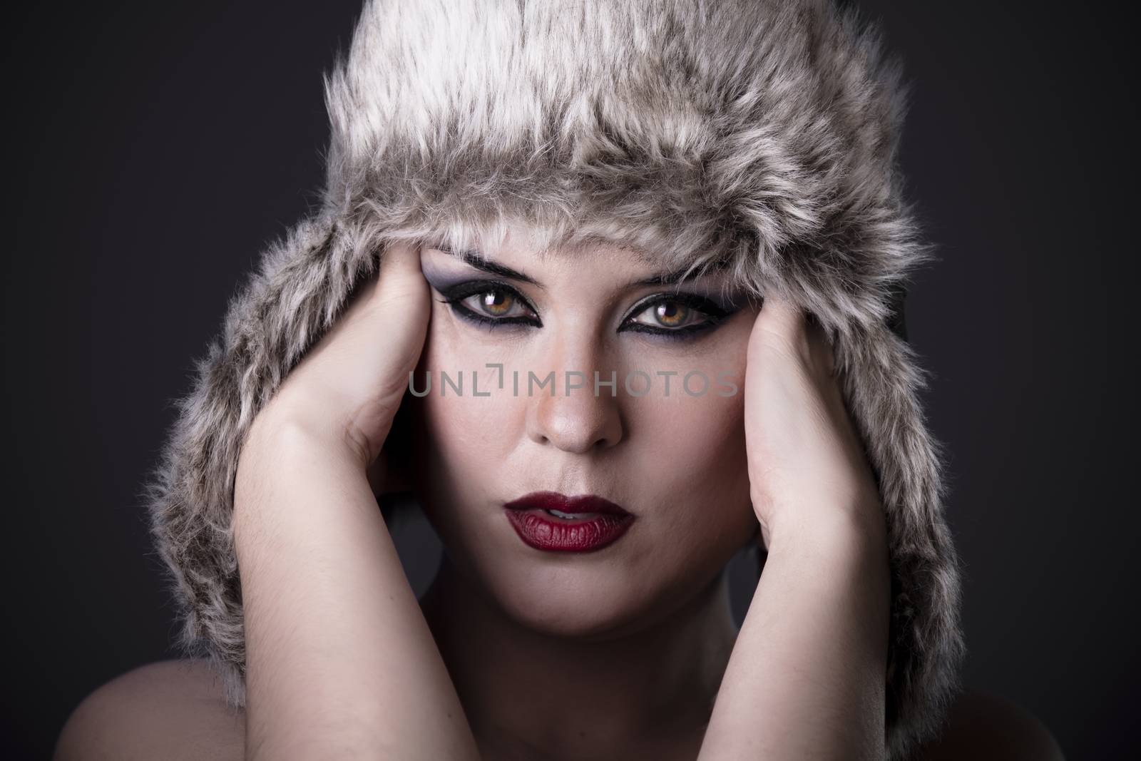 Girl with headache and Russian hat on dark background by FernandoCortes