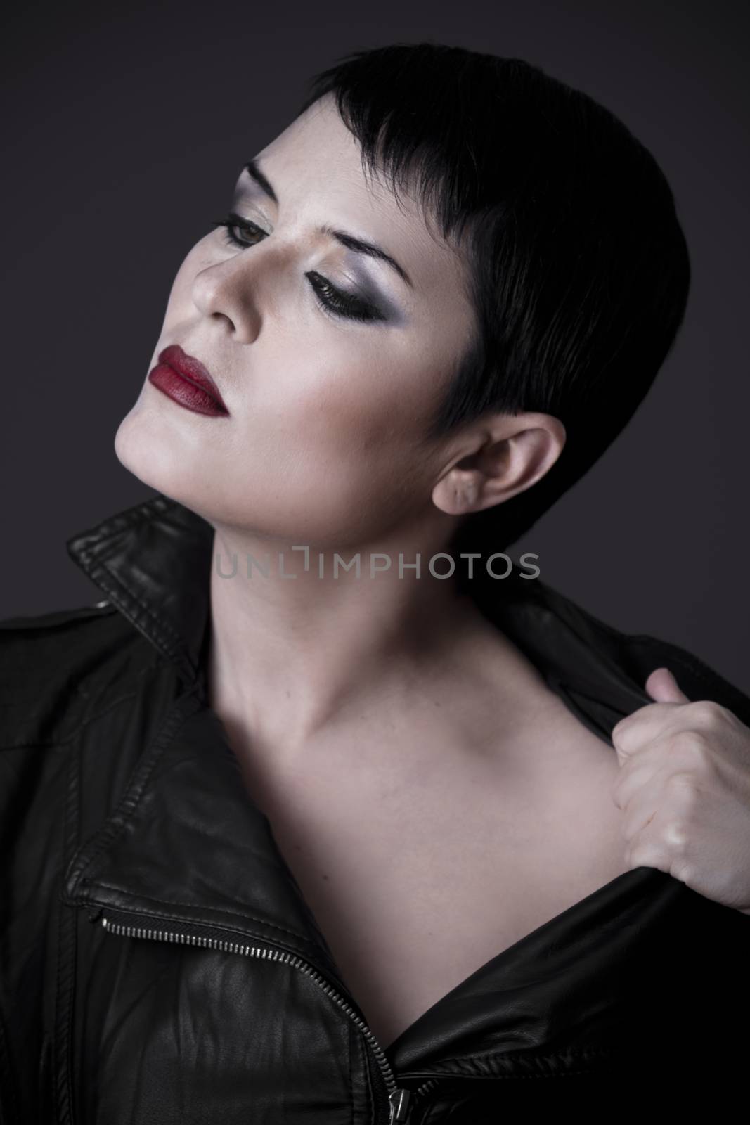 Beautiful sexy woman with black leather jacket on dark backgroun by FernandoCortes