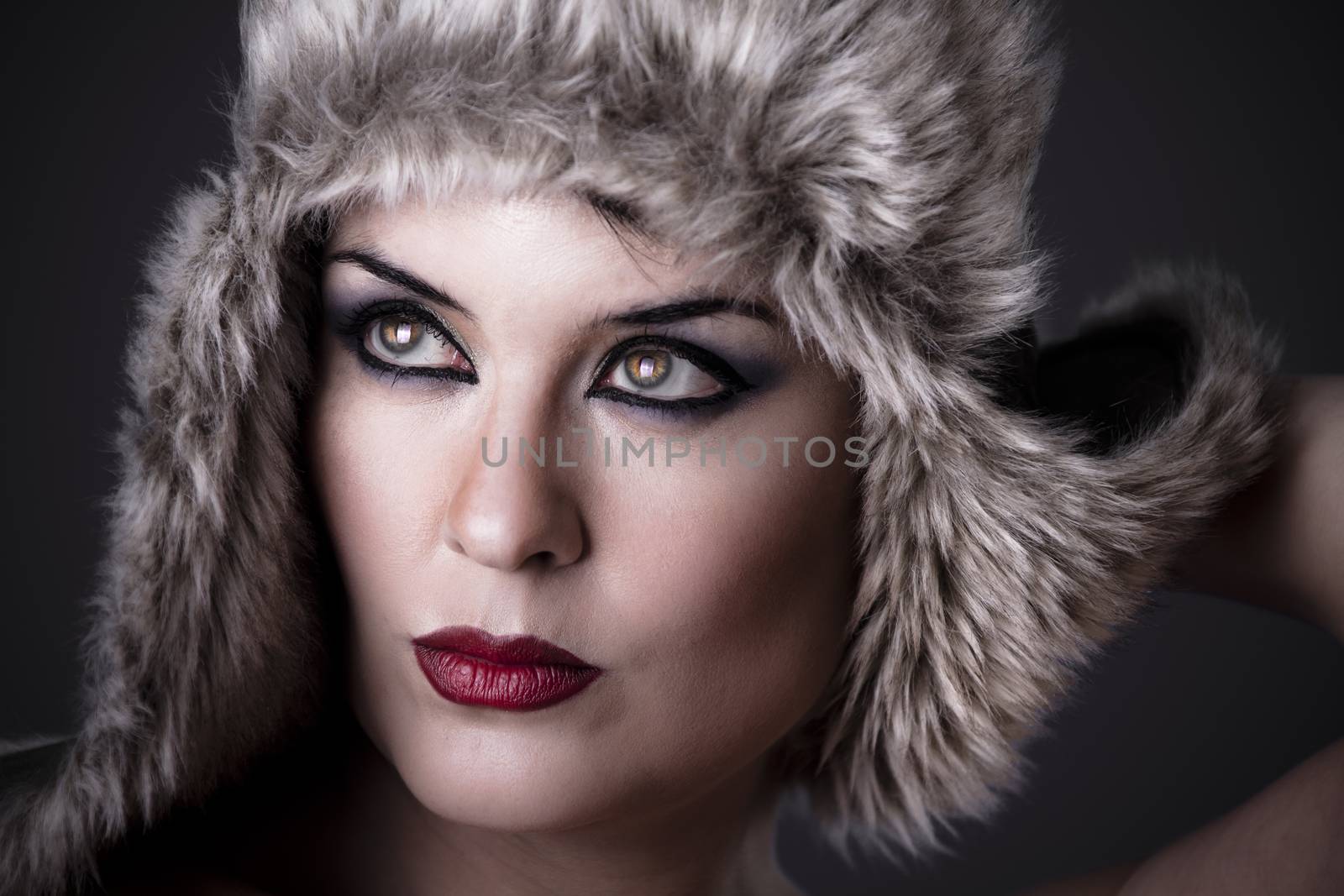 Female green-eyed woman with fur hat, winter concept