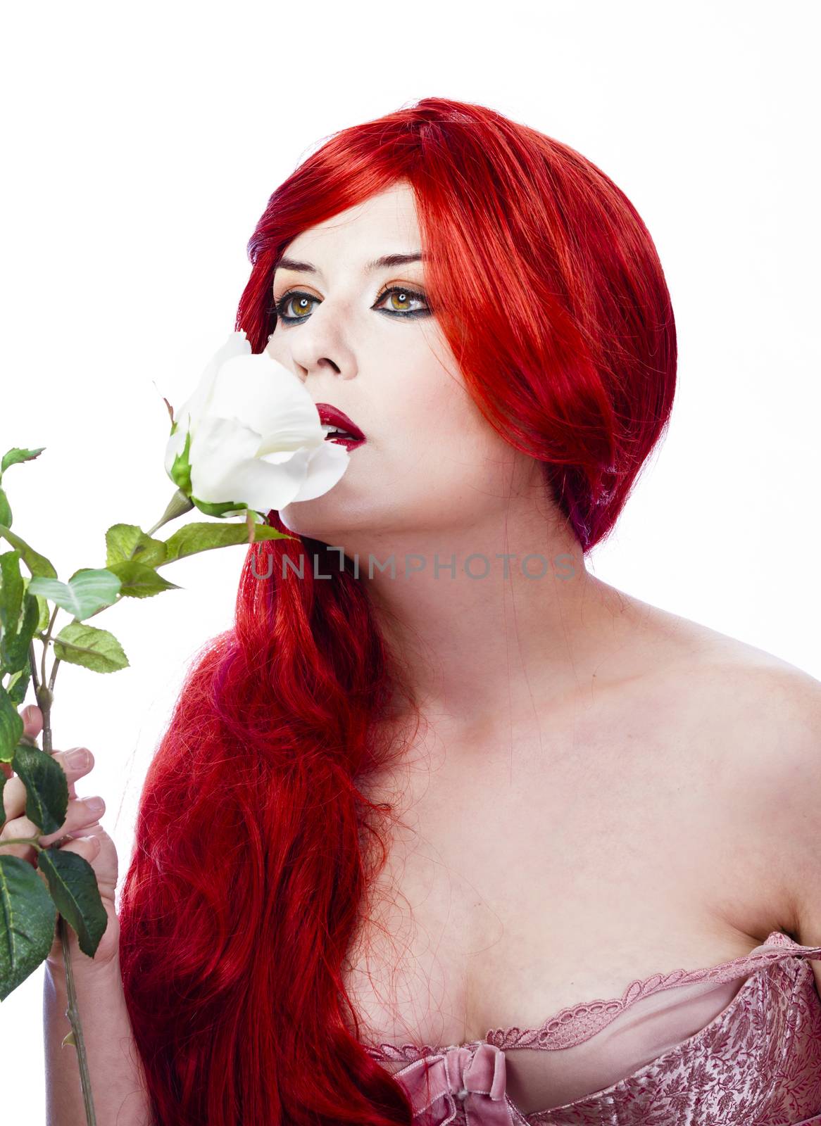 elegant woman with red hair smelling a bouquet of white roses