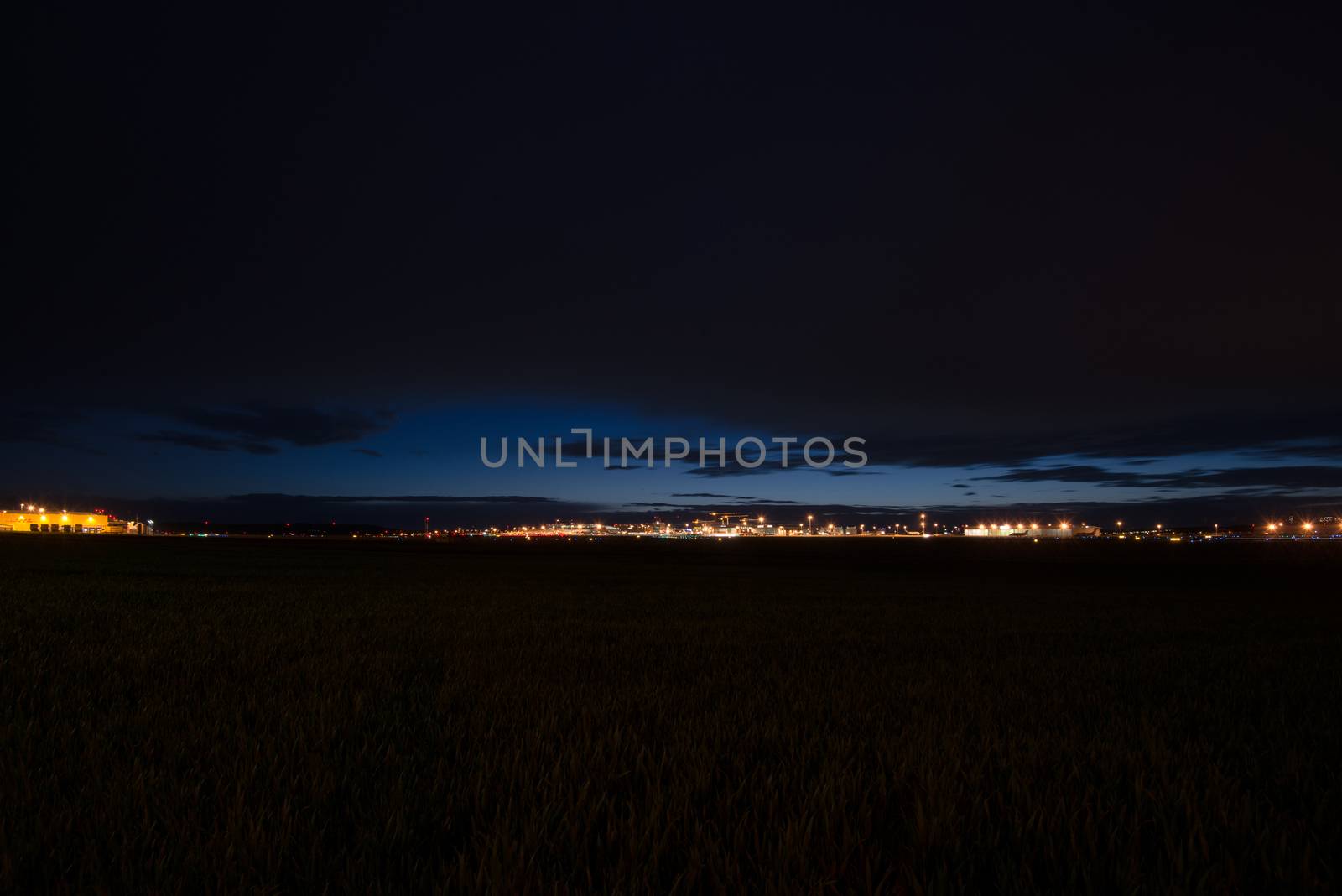 STUTTGART, GERMANY - MAY 6, 2014: Extreme wide angle shot of Stuttgart Airport at dusk with planes departing and arriving as seen from over the fields on May, 6, 2014 in Stuttgart, Germany. Stuttgart Airport is the 6th biggest airport in Germany, having a capacity of 14 million people per year.