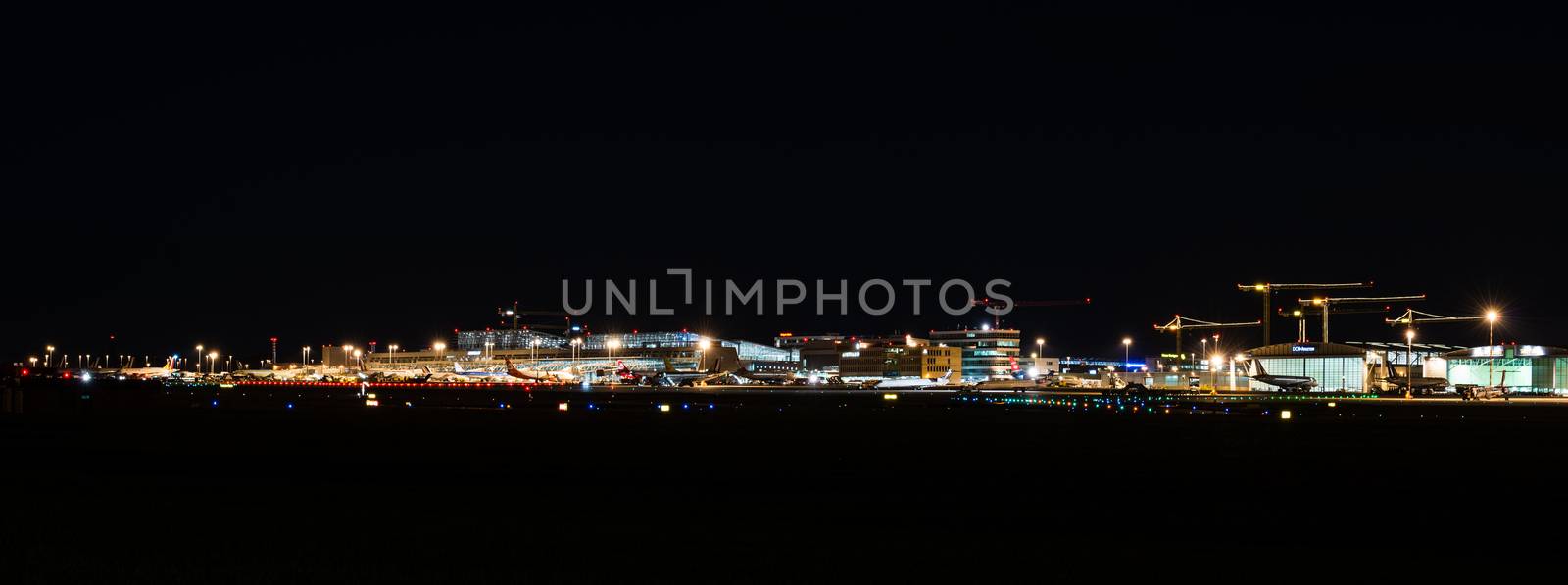 STUTTGART, GERMANY - MAY 6, 2014: Wide angle shot of Stuttgart Airport at dusk with planes departing and arriving as seen from over the fields on May, 6, 2014 in Stuttgart, Germany. Stuttgart Airport is the 6th biggest airport in Germany, having a capacity of 14 million people per year.
