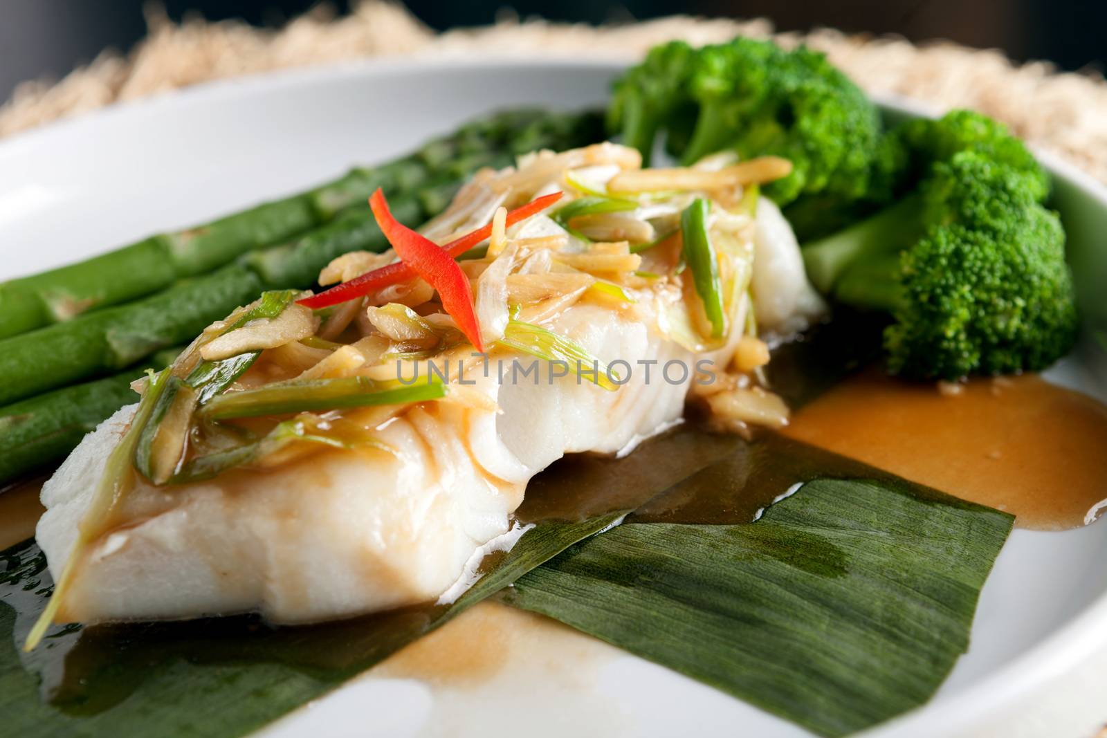 Freshly prepared Thai style sea bass fish dinner with asparagus and appetizer with a contemporary presentation.