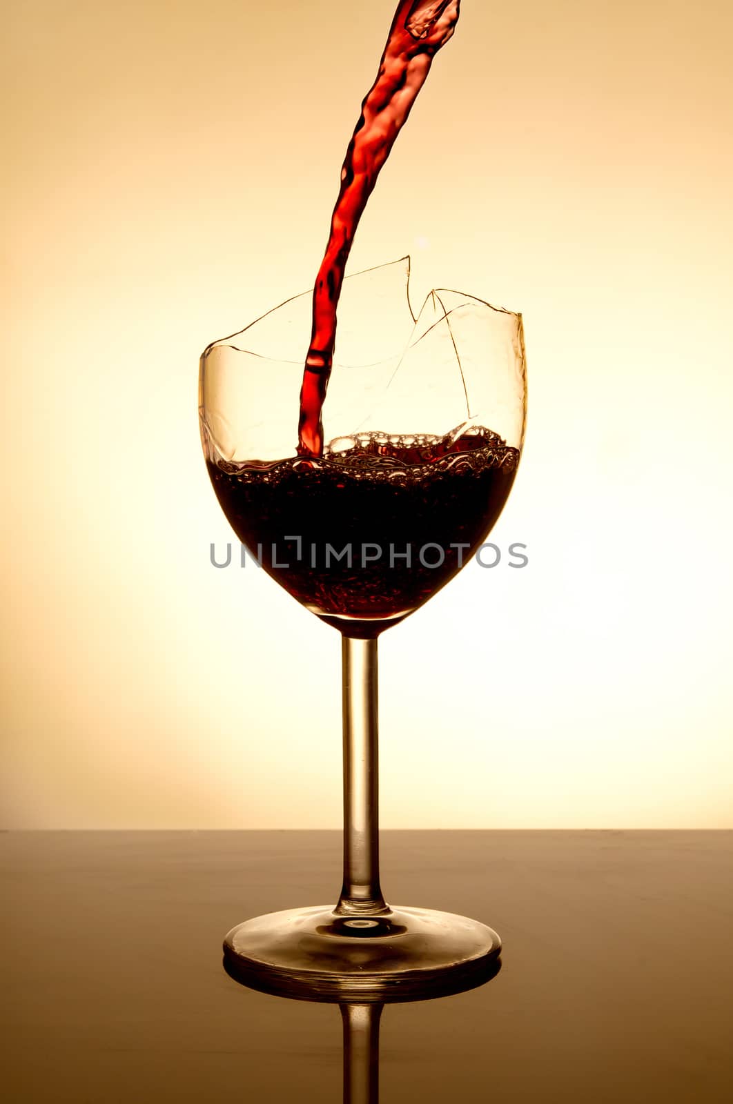 Pouring red vine into a broken glass