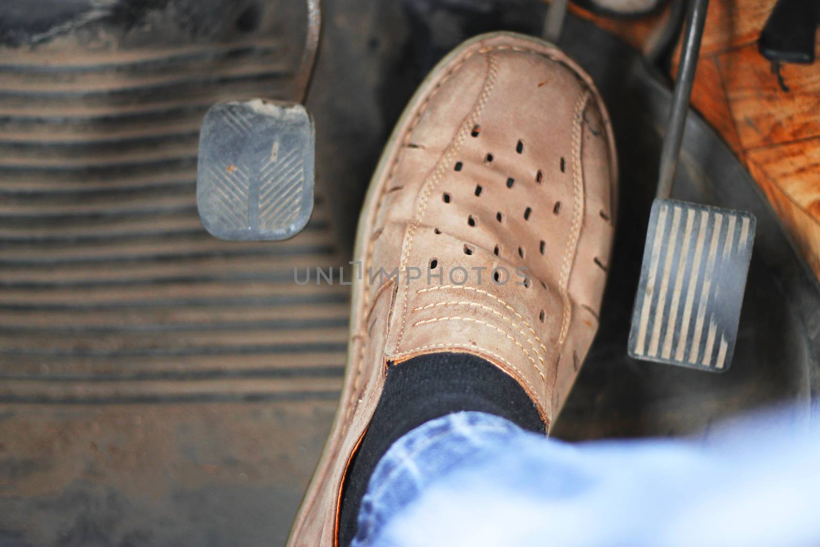 Mans feet pushing on the accelerator of automobile