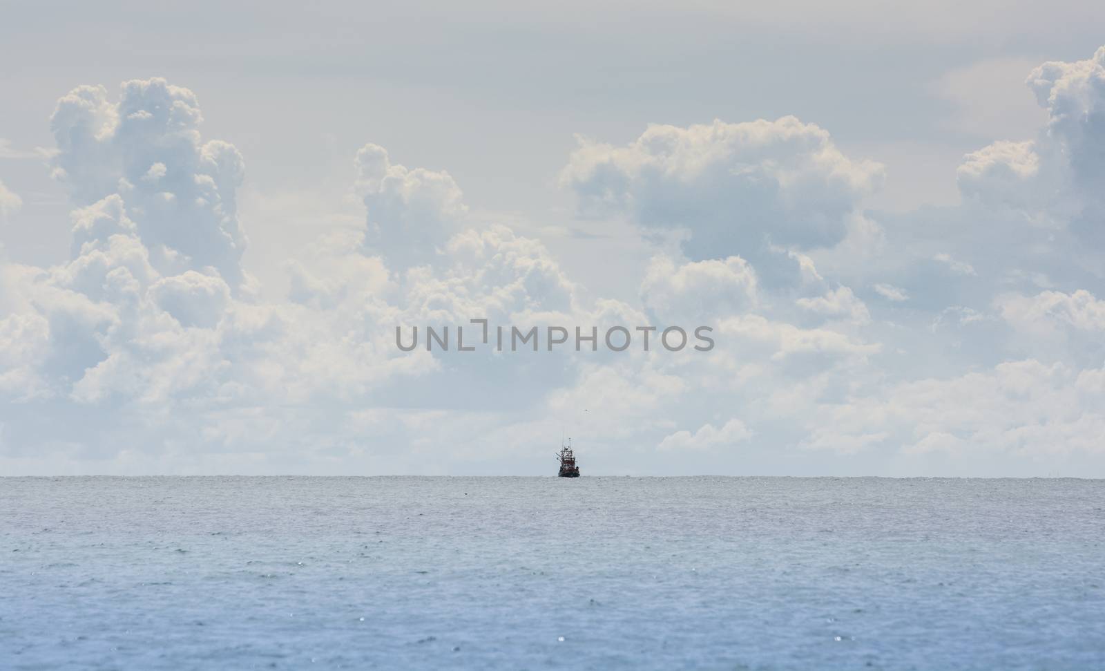 Fishing boat at the coast of Thailand on cloud background