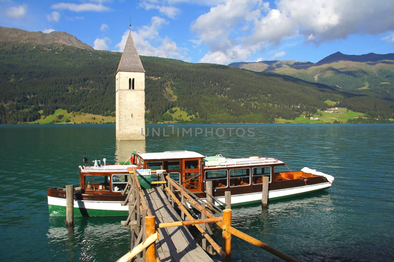 sunken church tower in lake Reschen with boat dock