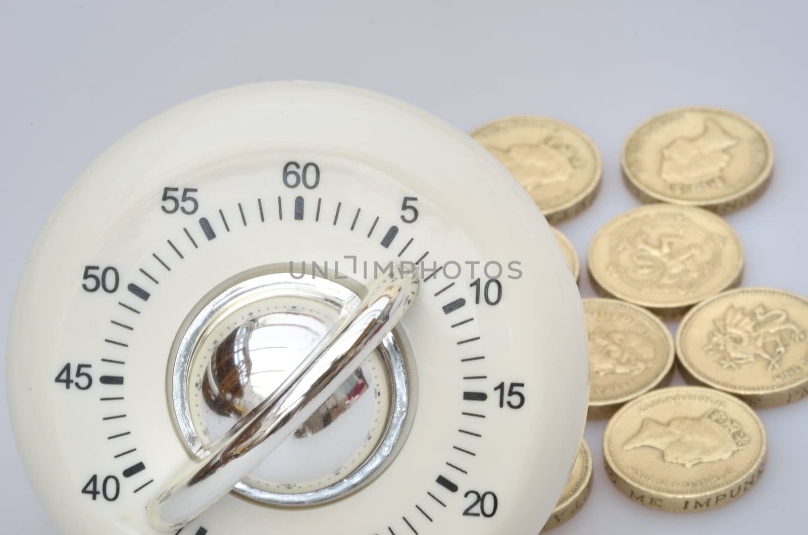 Timer in close up with group of pound  coins