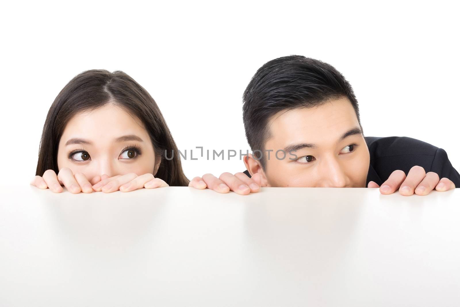 Asian business man and woman hide under the table and looking somewhere.