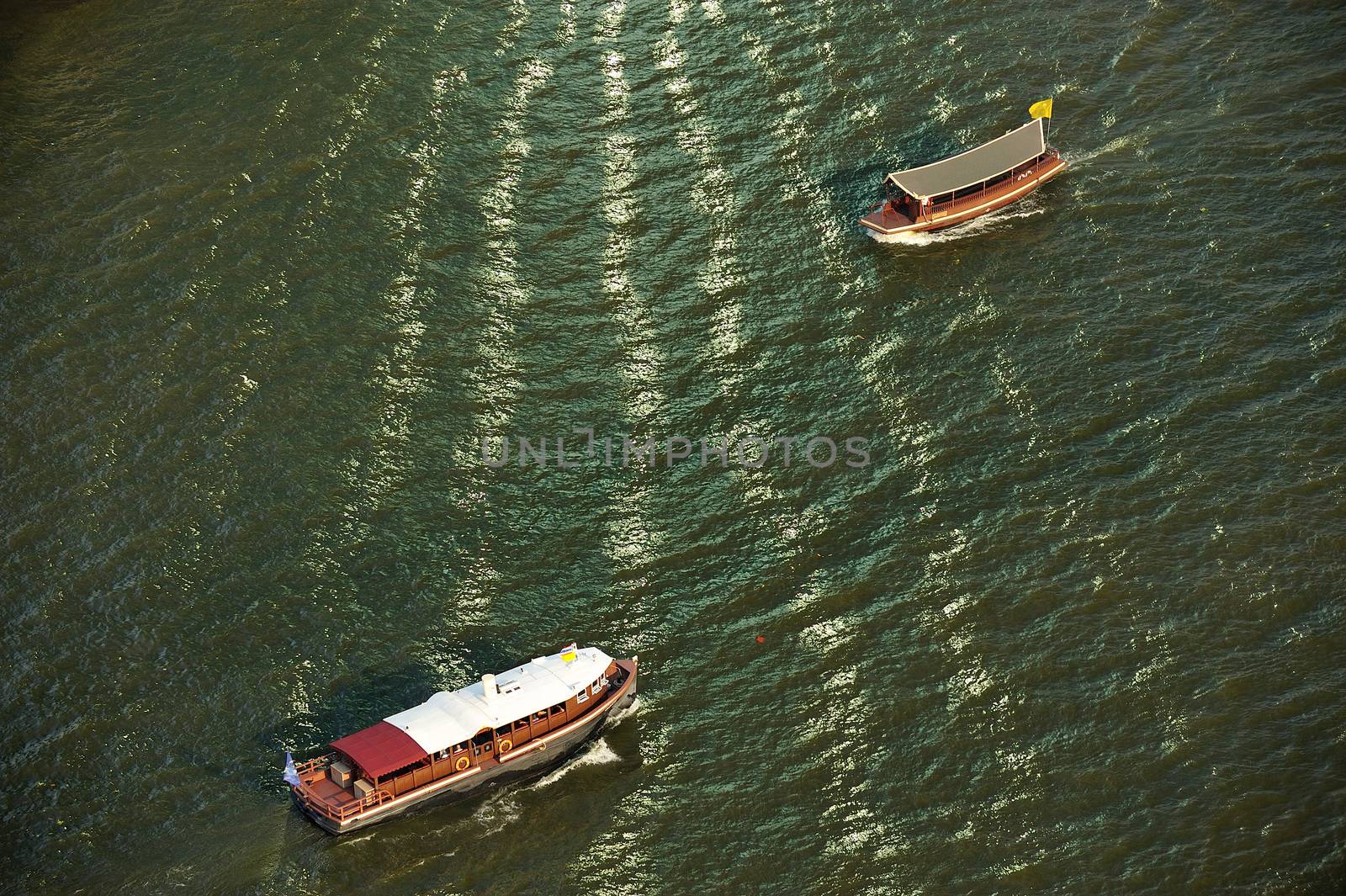 boat and sunlight reflection with Chao Phraya river, Thailand. by think4photop