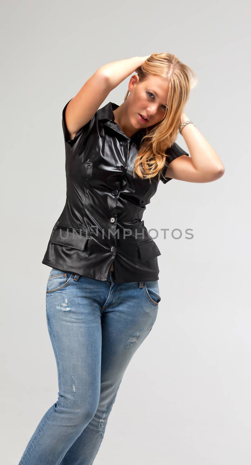 blonde woman in a leather vest and jeans