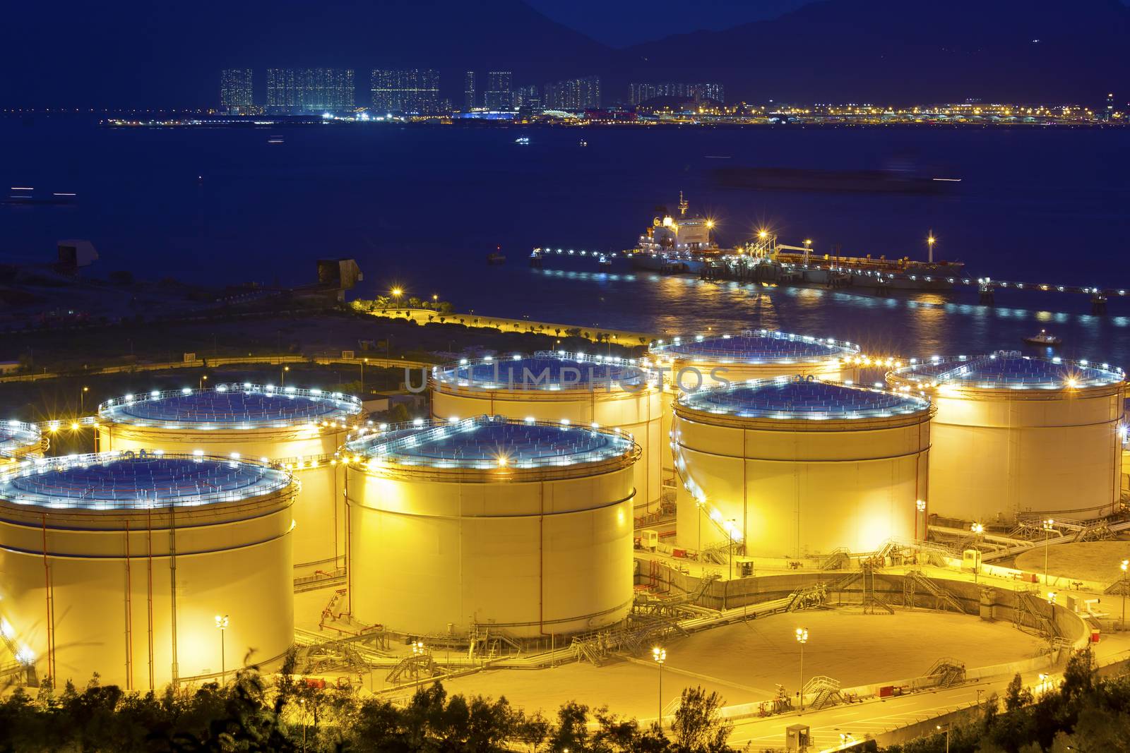Big Industrial oil tanks in a refinery at night by kawing921