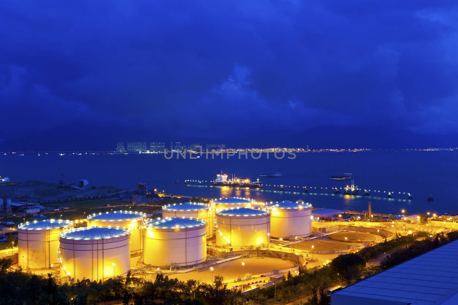 Big Industrial oil tanks in a refinery at night by kawing921
