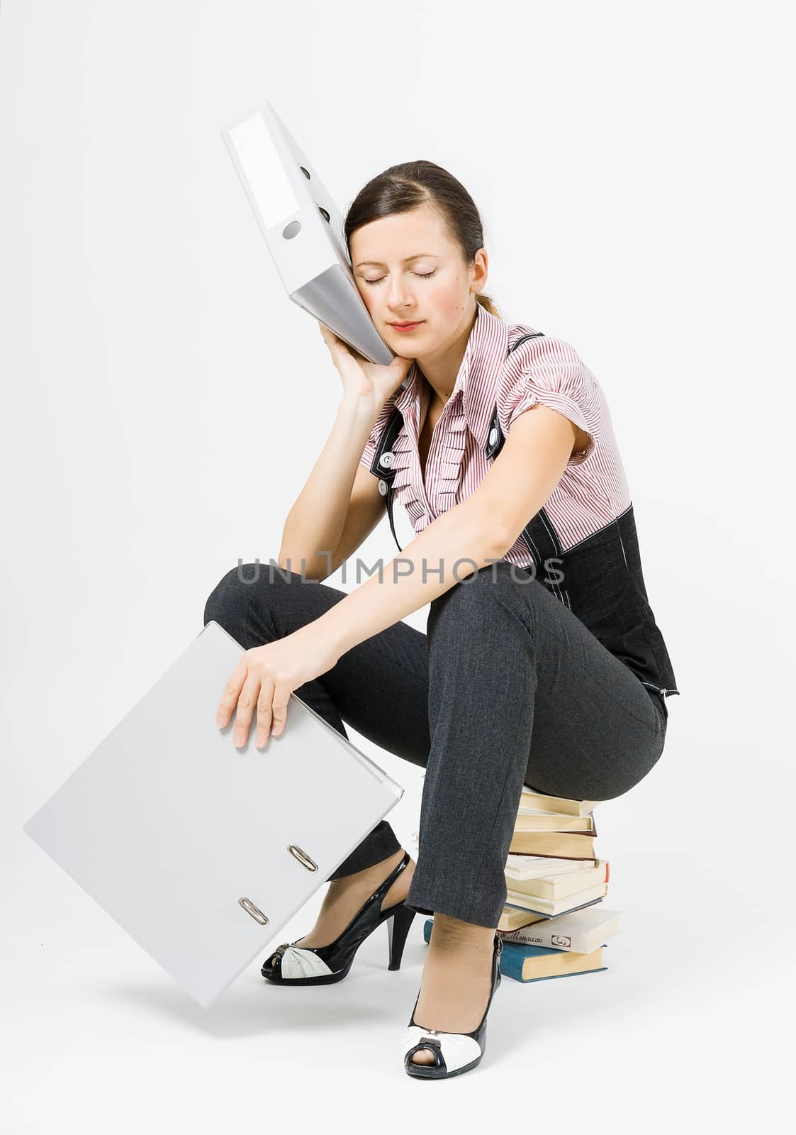 Young tired woman sleeps sitting on books