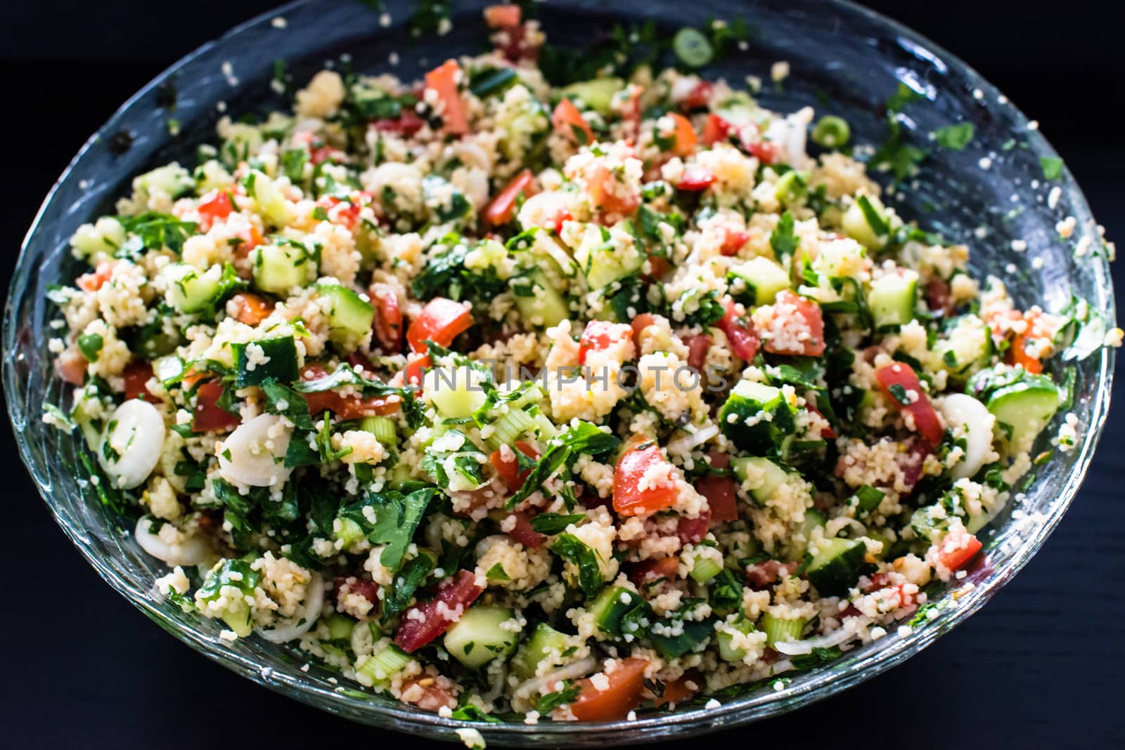 delicious and healthy tabbouleh made of couscous and various vegetables in a huge salad bowl