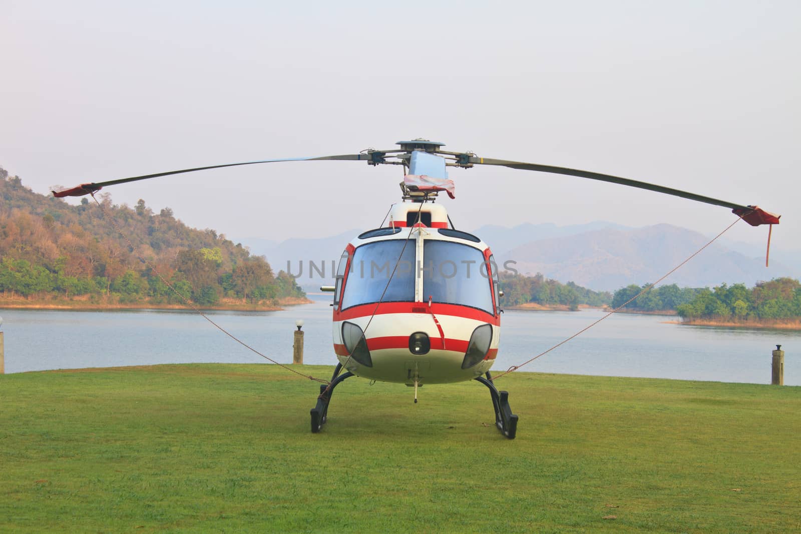 helicopter standing on landing strip in airfield near lake in morning