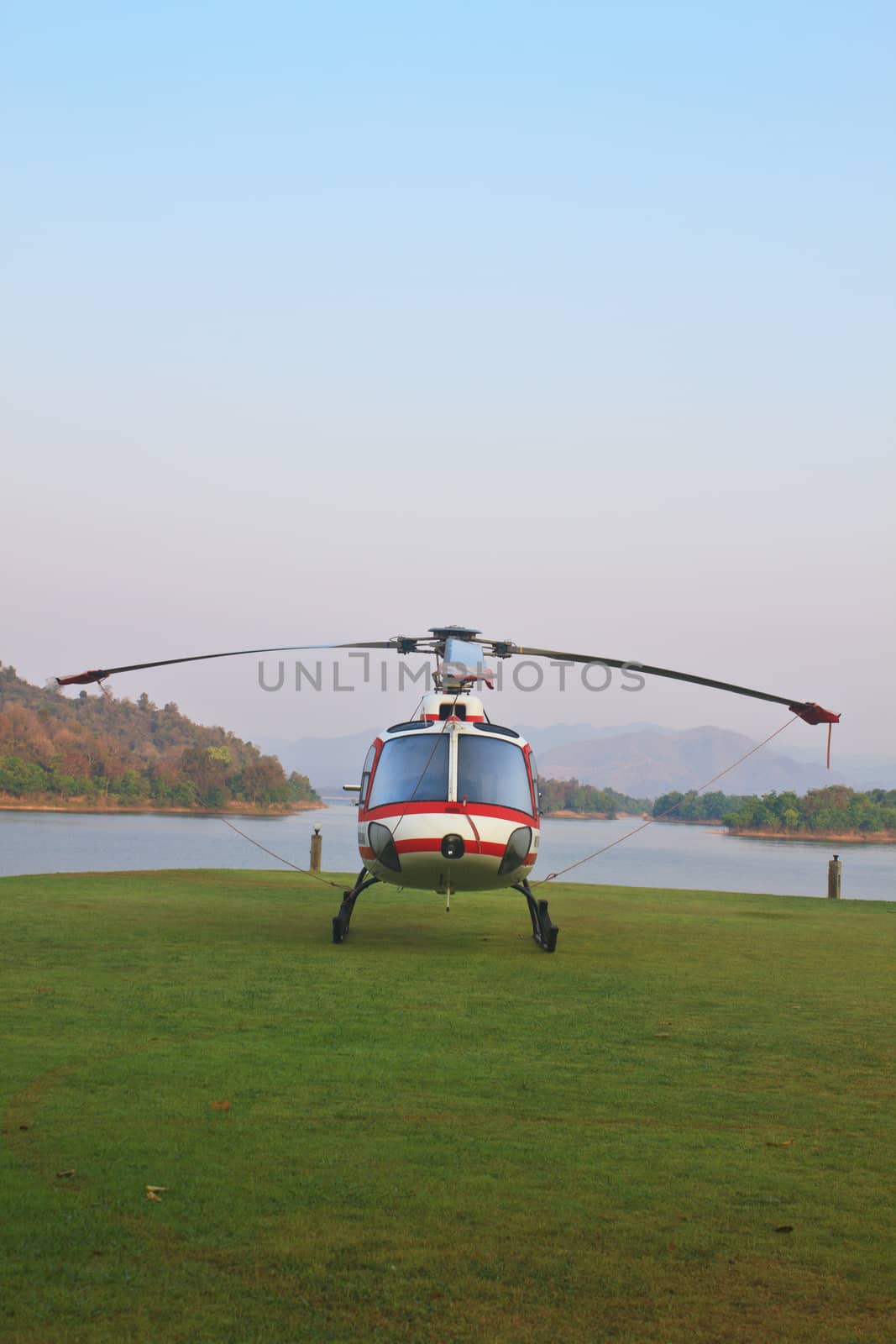 helicopter standing on landing strip in airfield near lake in morning