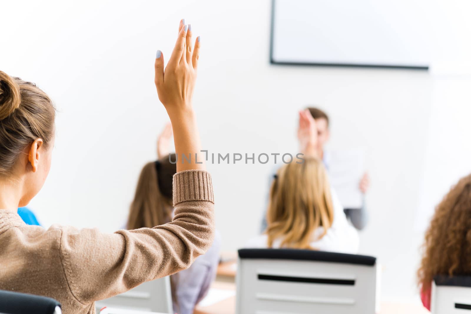 image of a female hand raised in university classroom