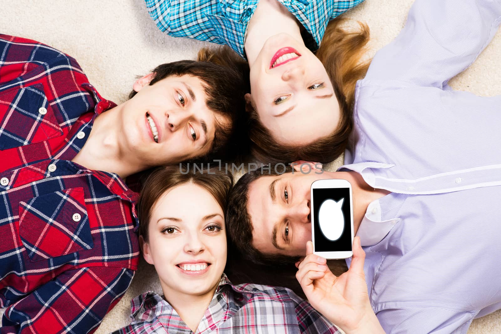 four young people are together, the young man pressed his lips to the phone