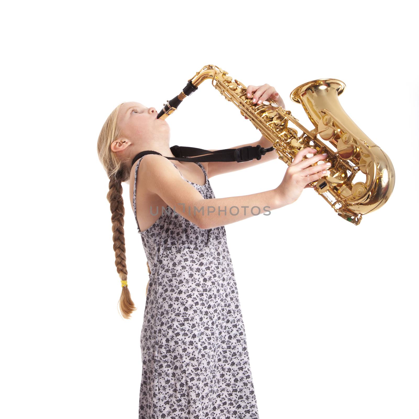 young girl in dress and her saxophone in studio against white background