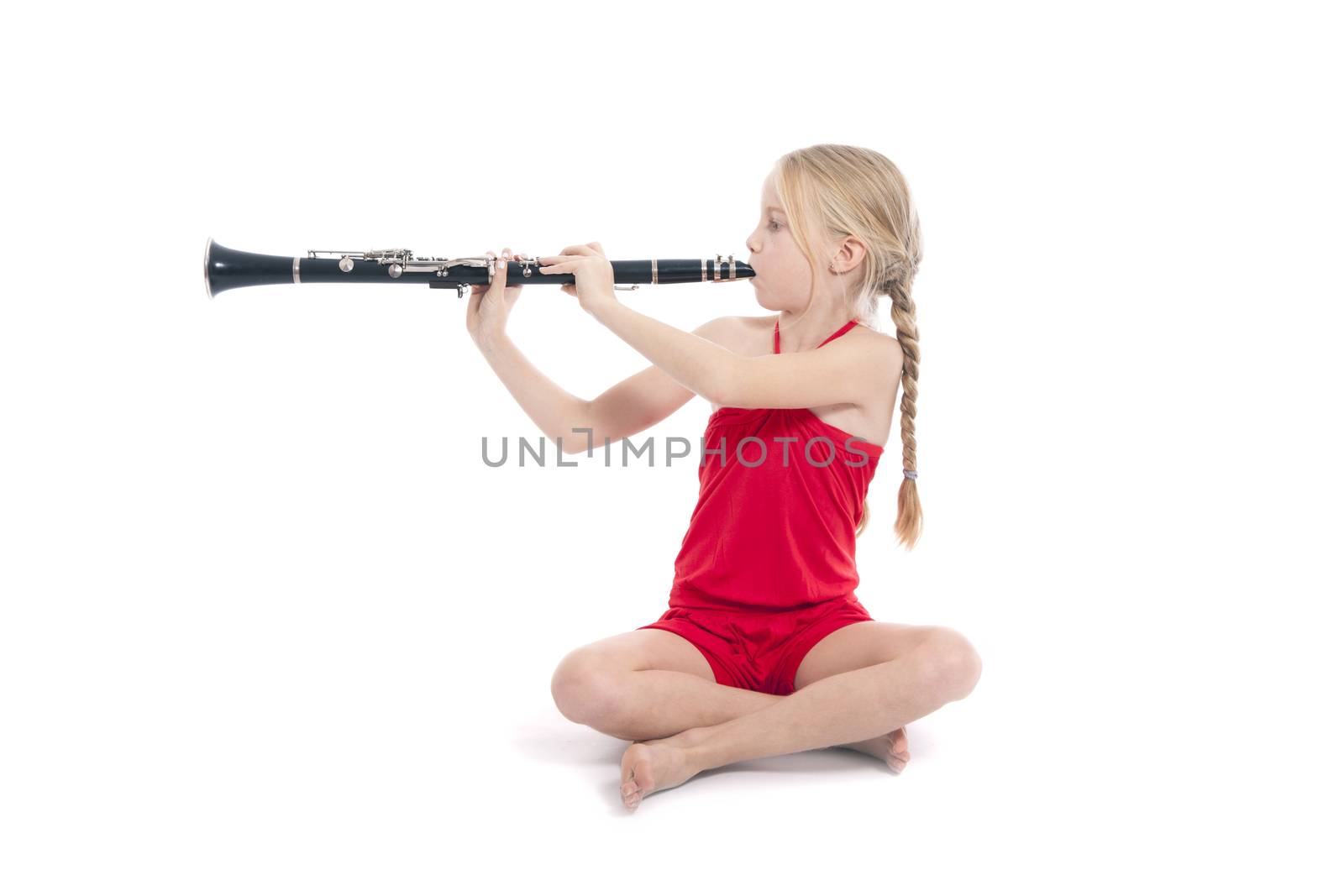 young sitting girl in red playing clarinet by ahavelaar