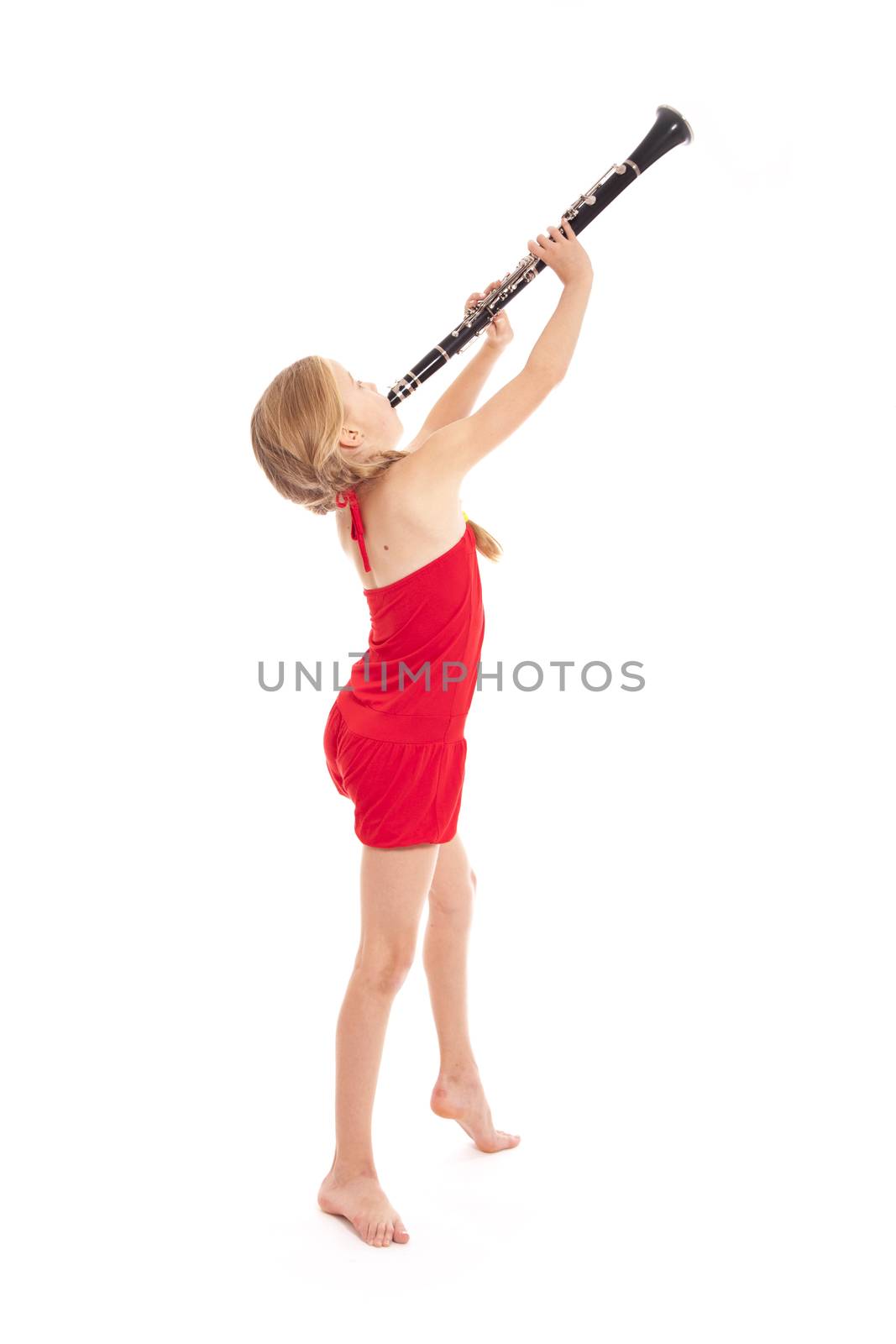 young girl in red playing clarinet against white background