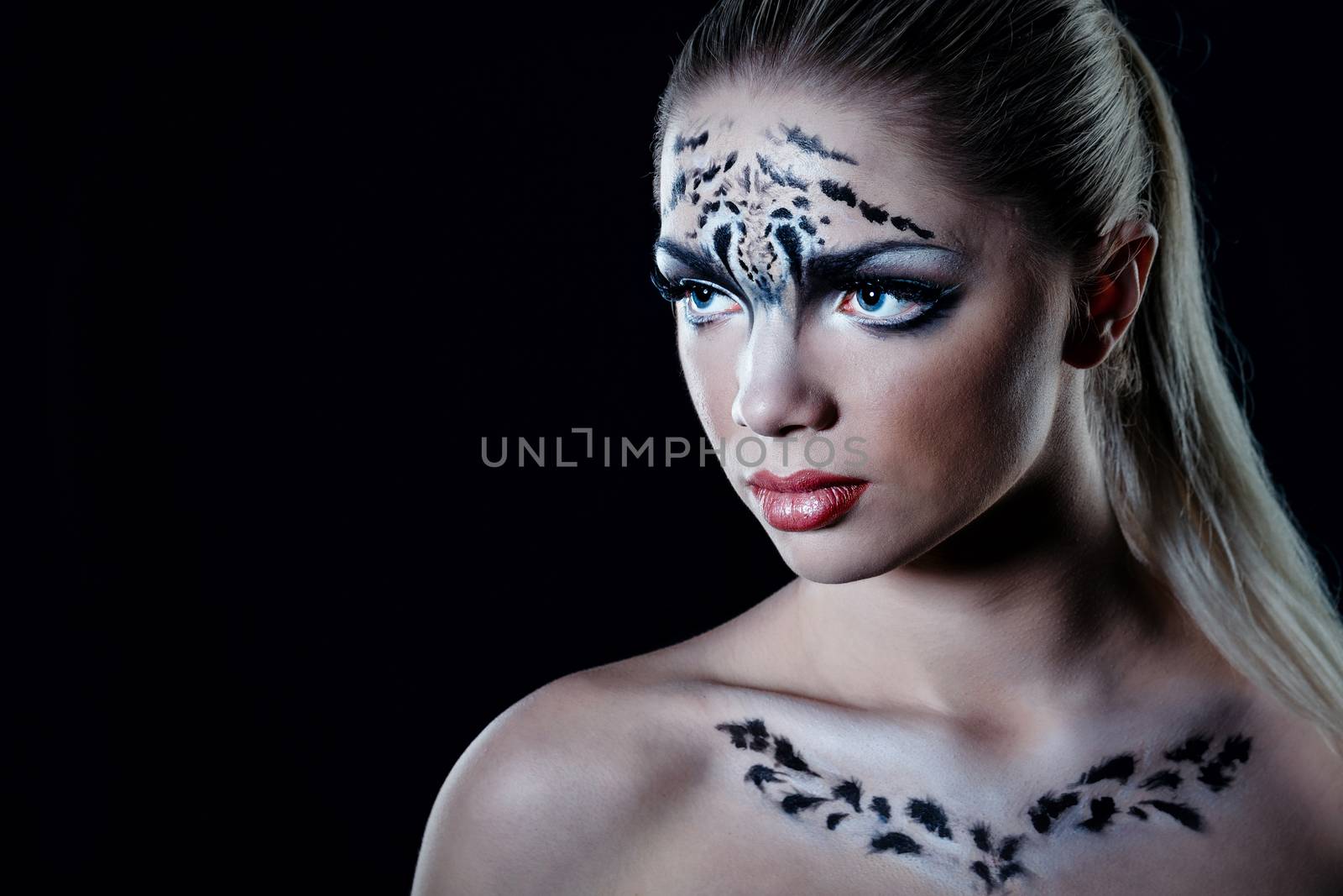 Attractive young girl with make-up snow leopard close-up portrait