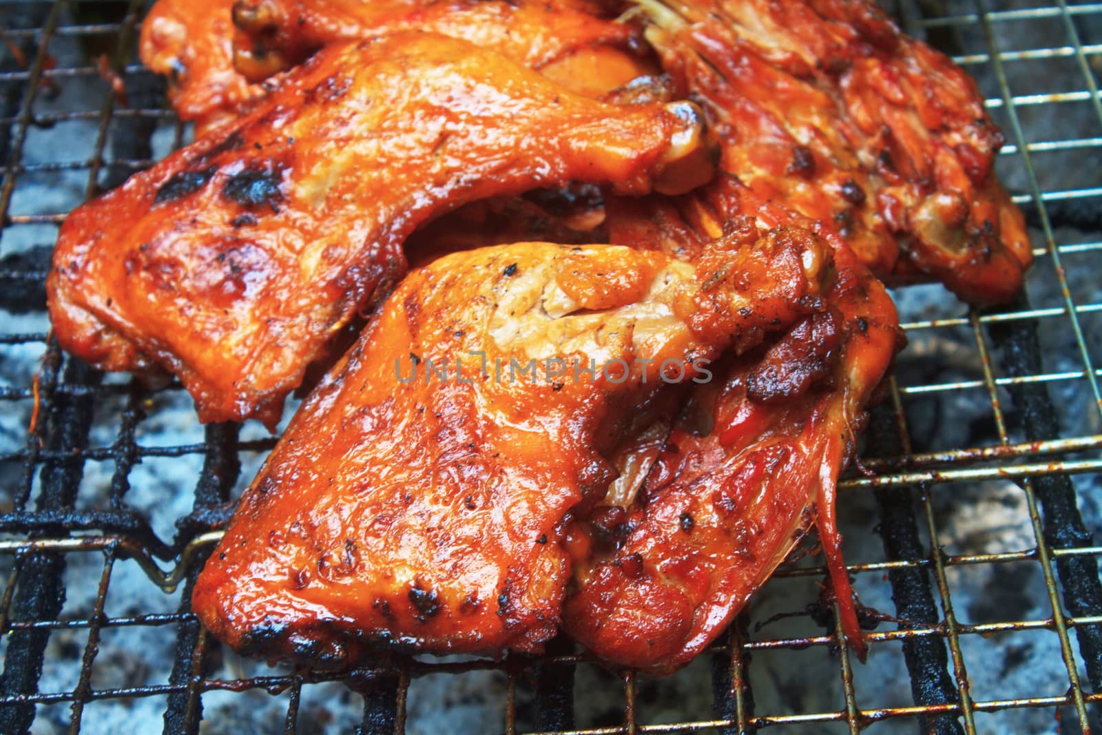 Grilled chicken thigh on the flaming grill 