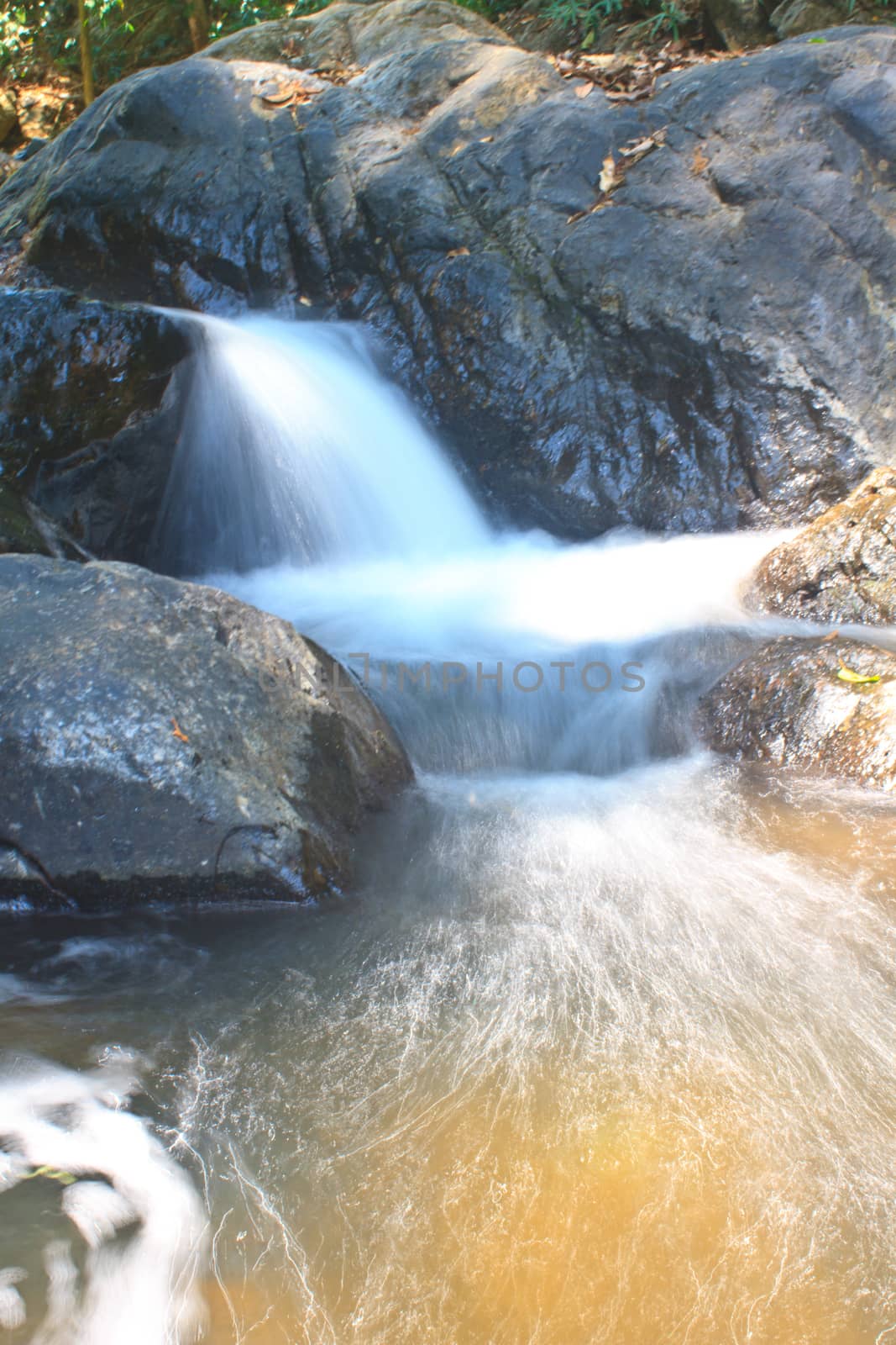 waterfall and rocks covered with moss in deep forest