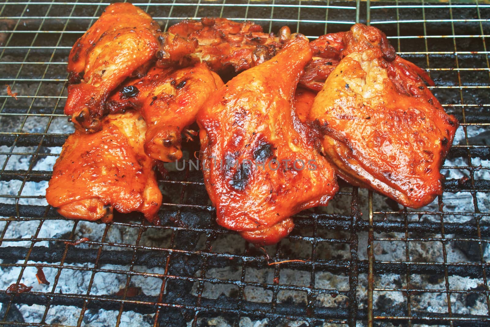 Grilled chicken thigh on the flaming grill 