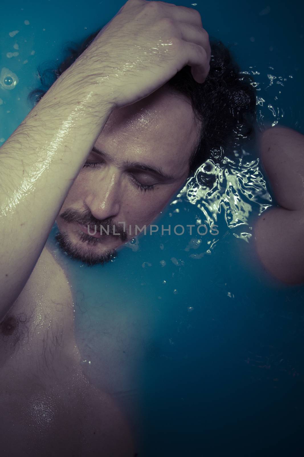 Depression, man in blue tub full of water, sadness concept by FernandoCortes