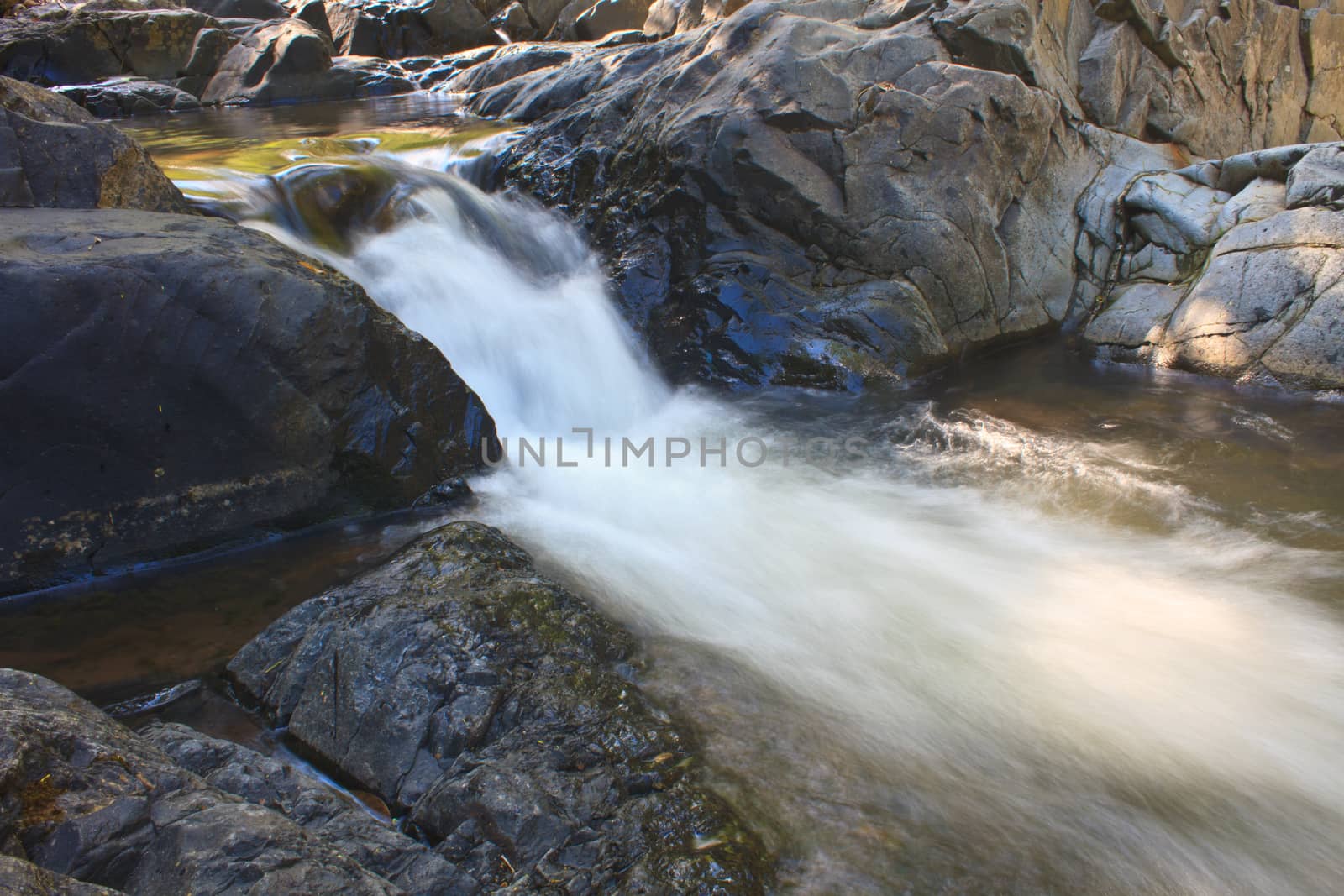 waterfall and rocks covered with moss in deep forest